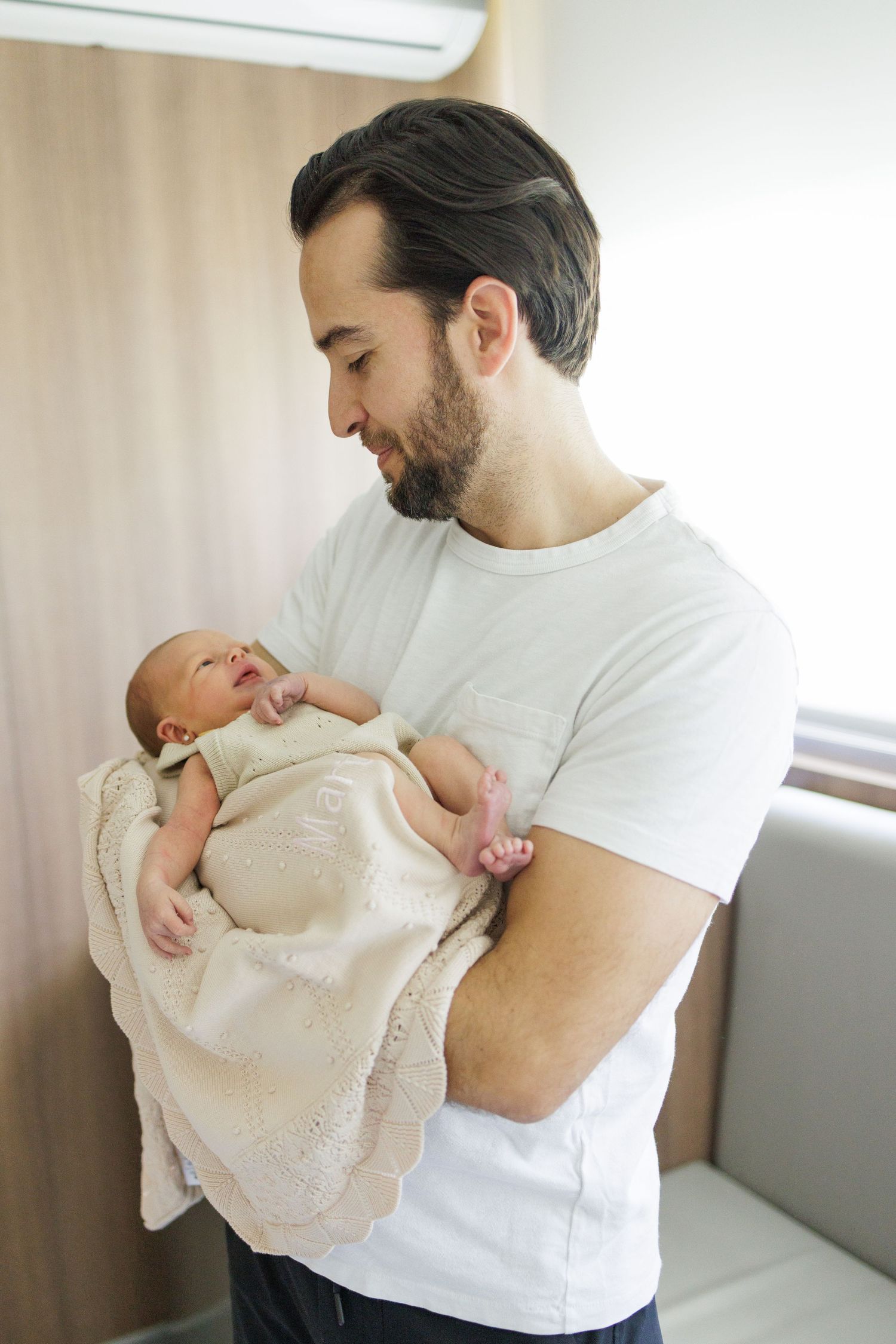 Tender moments with a baby wearing a white christening gown.