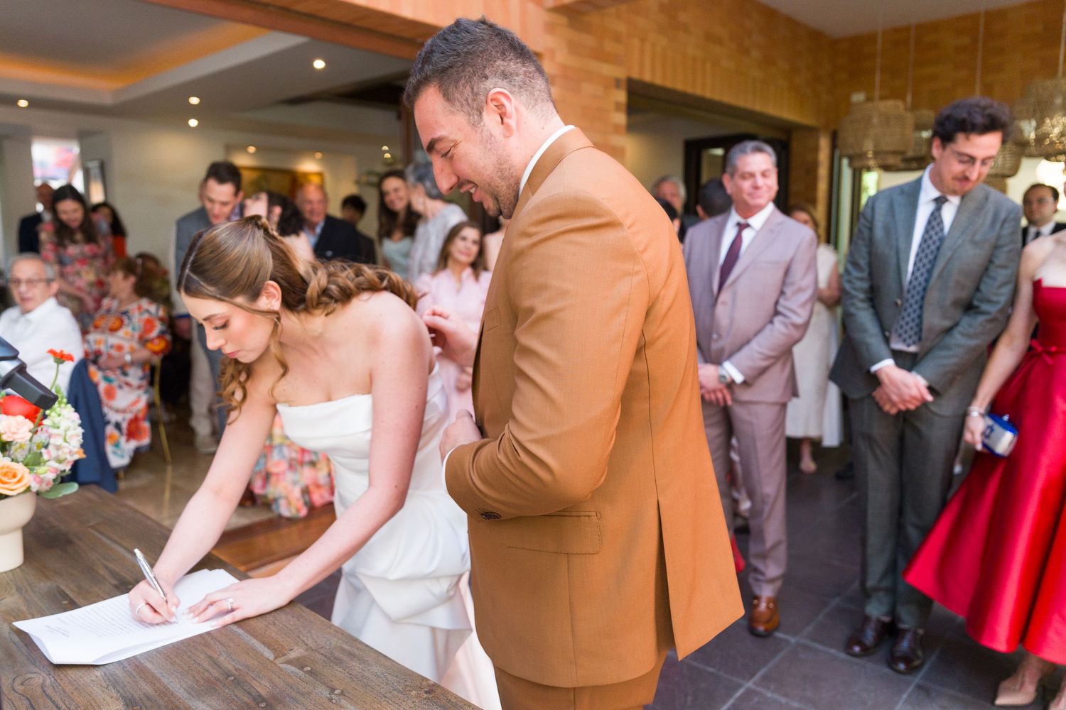 Wedding celebration with guests mingling and dancing in an indoor venue with brick walls.