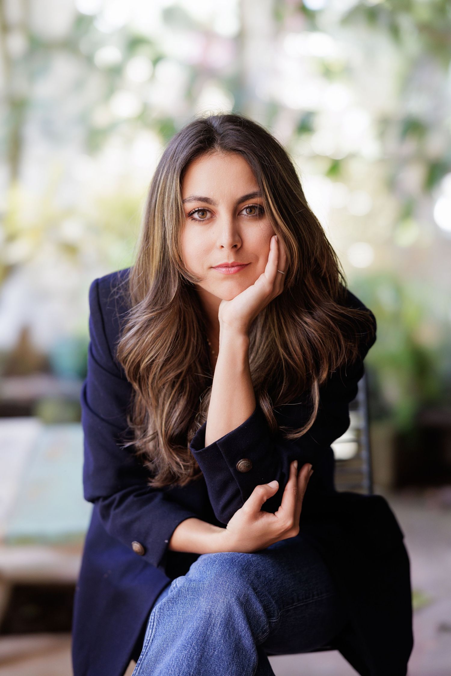 Casual portrait in navy blazer with natural garden background.