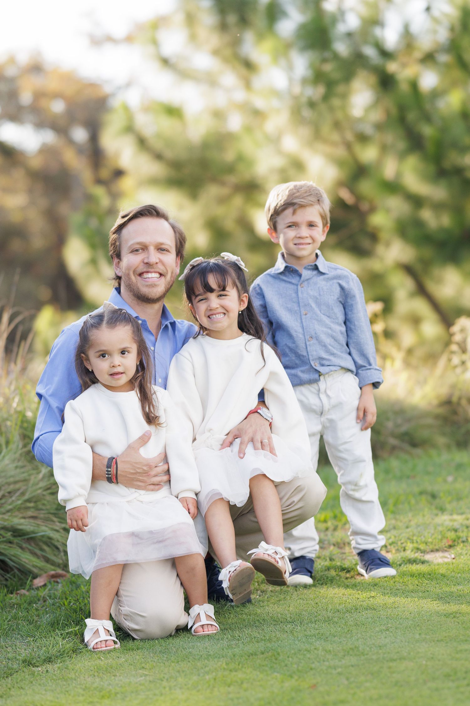 Family members sitting together on green grass during an outdoor photo session.