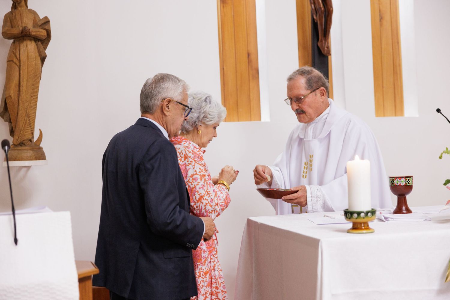 Religious ceremony taking place in a church with wooden beams and crosses.