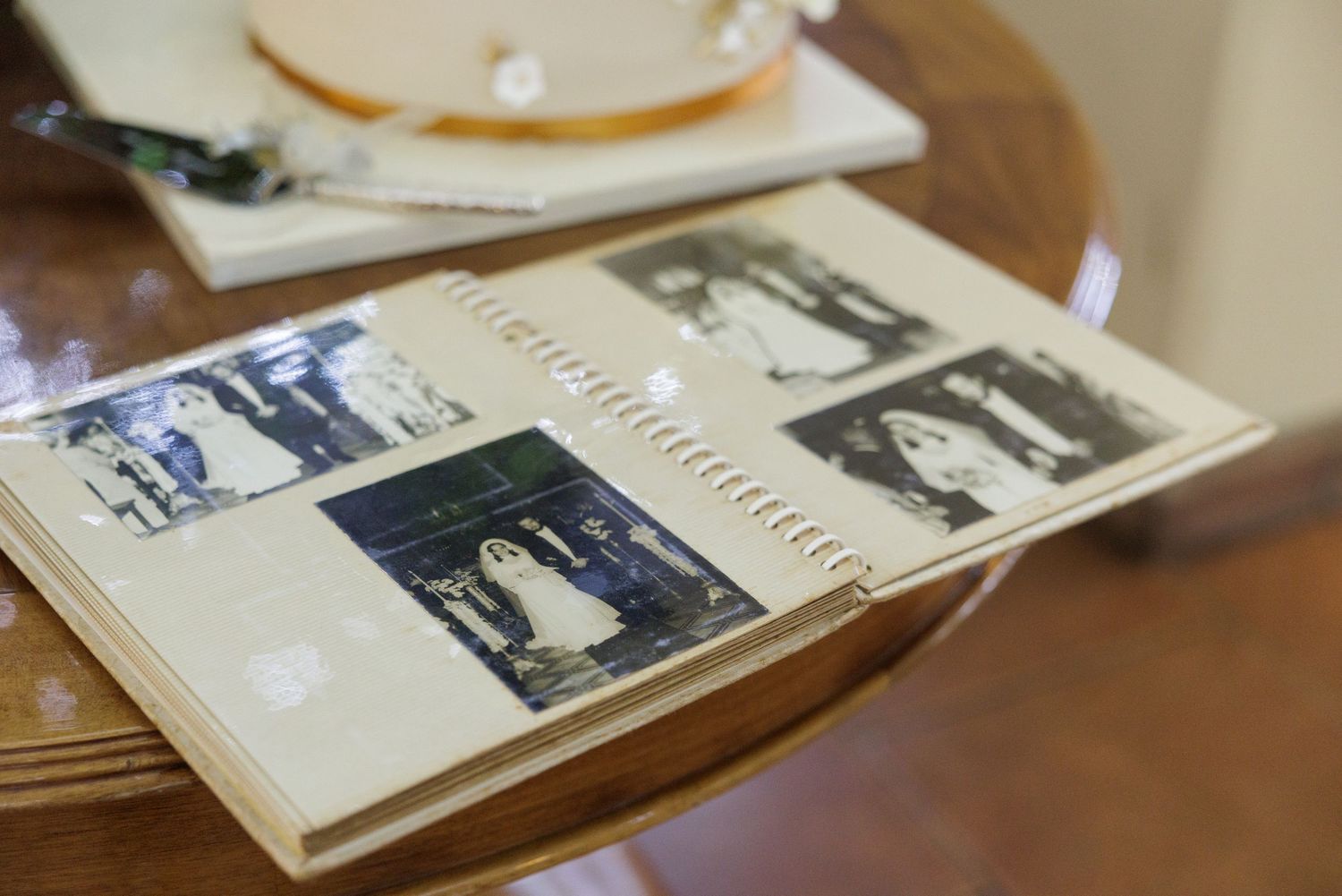 Collection of vintage black and white photographs displayed on a wooden surface.