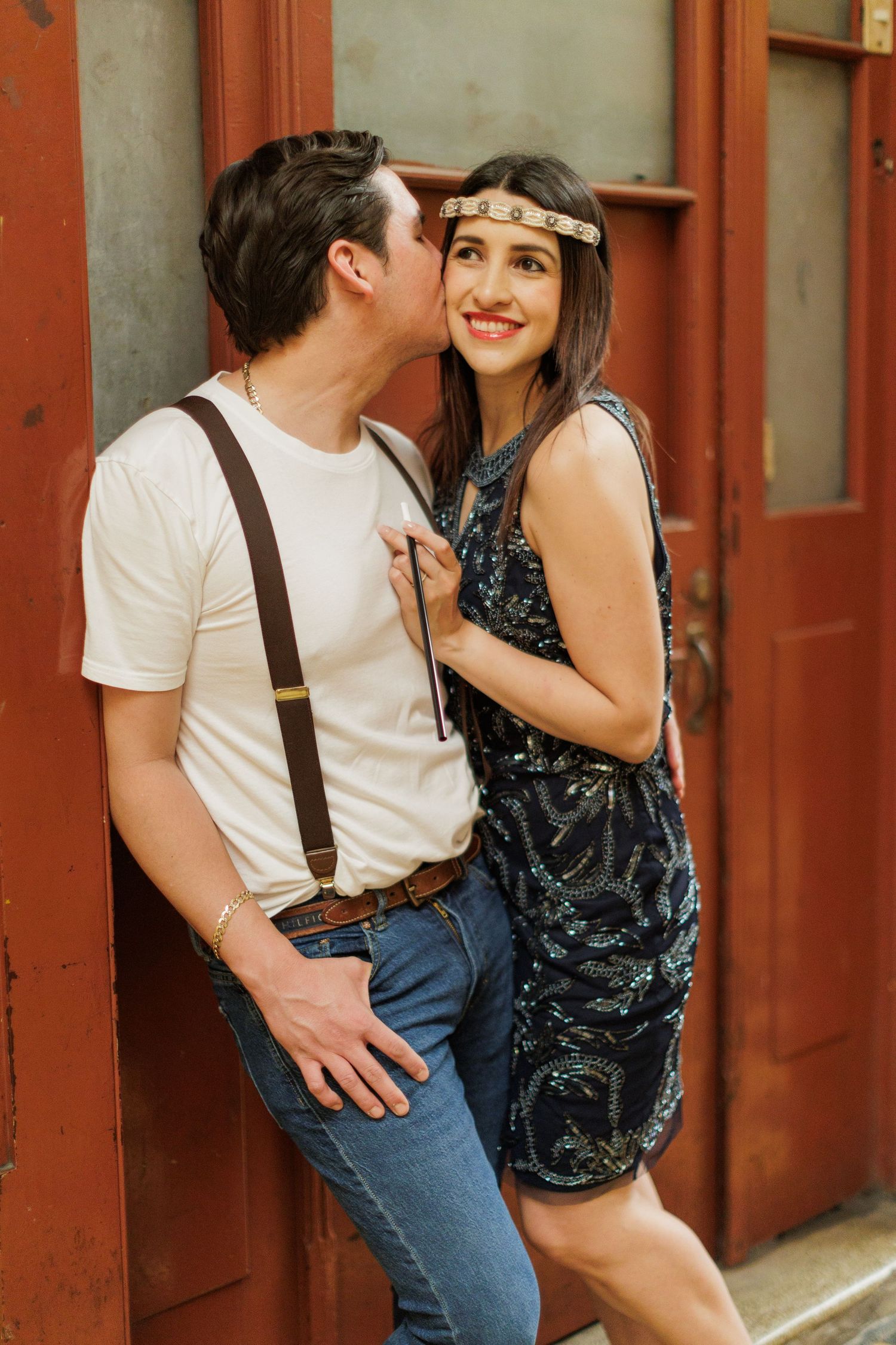 Romantic sequence showing couple in vintage-inspired outfits against rustic red doors.