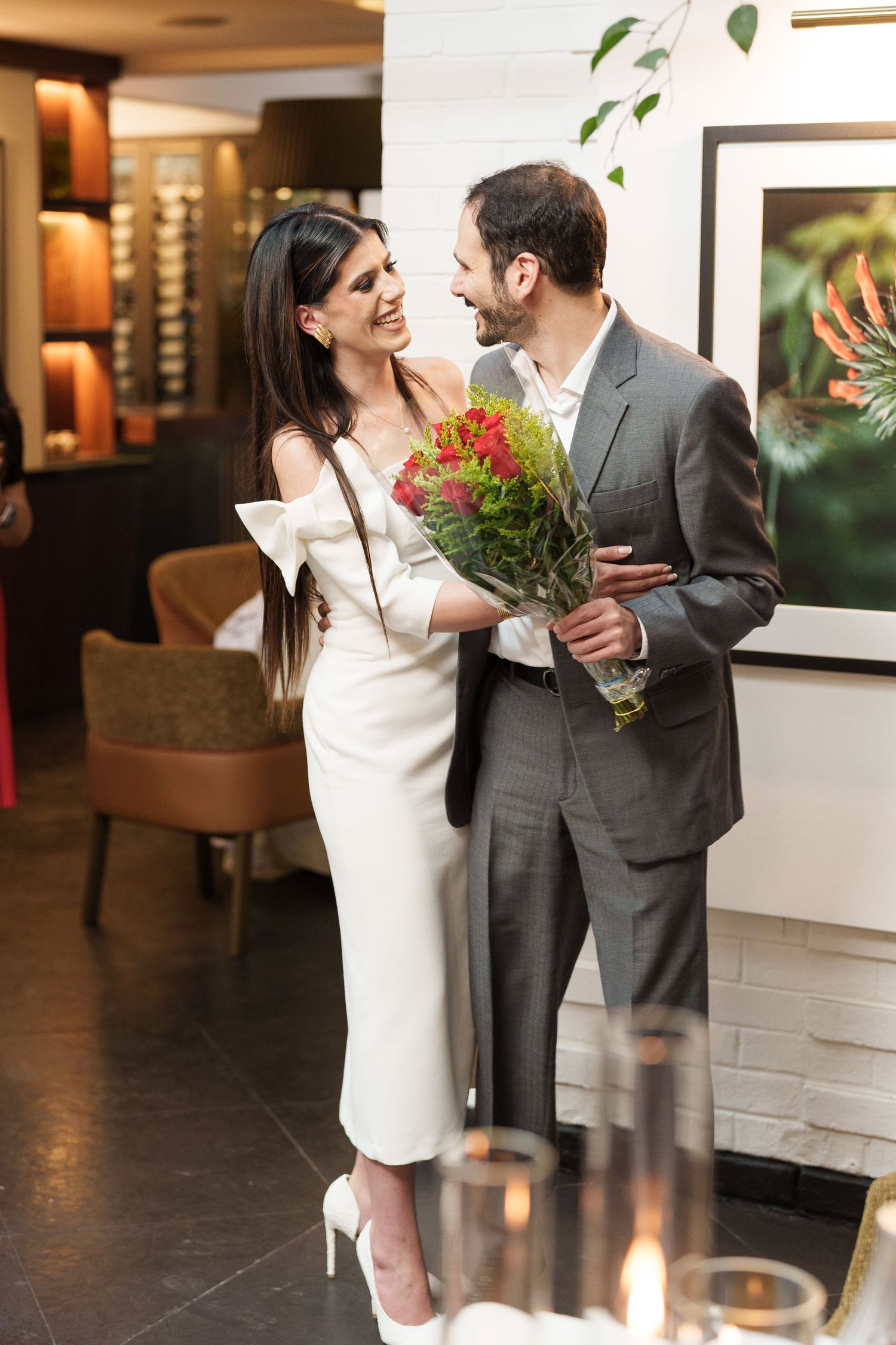 Elegant couple in formal attire share intimate moments in an art gallery setting.
