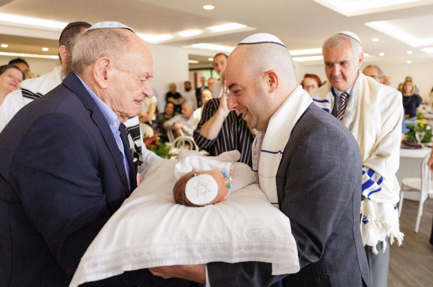 Jewish religious ceremony with men in yarmulkes examining ritual object.