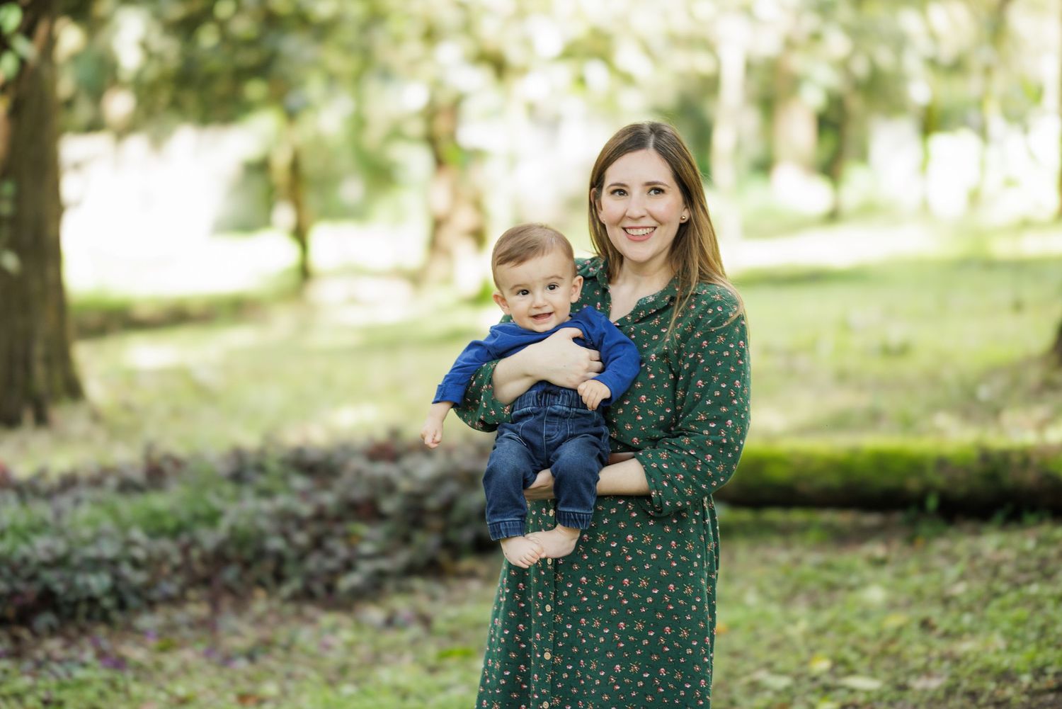 Mother and child enjoying a sunny day in a park with natural greenery.