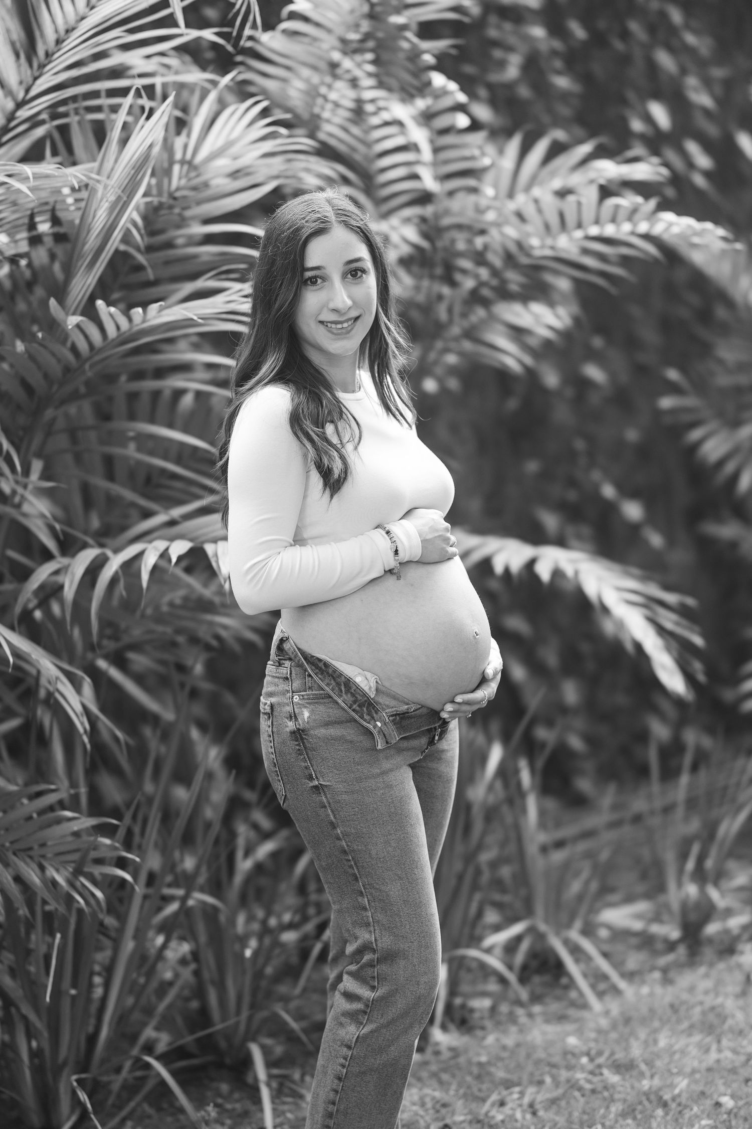 Black and white portrait series showing person in casual denim against tropical foliage.