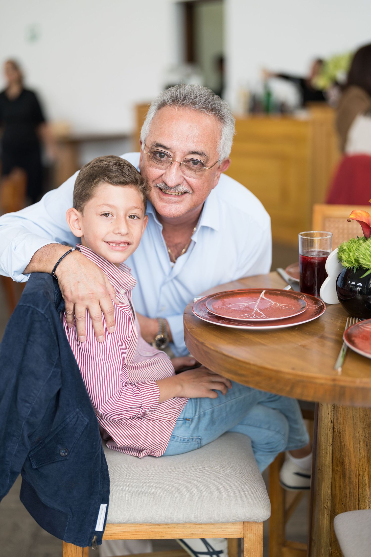Family members share a joyful moment at a dining table during a celebration.