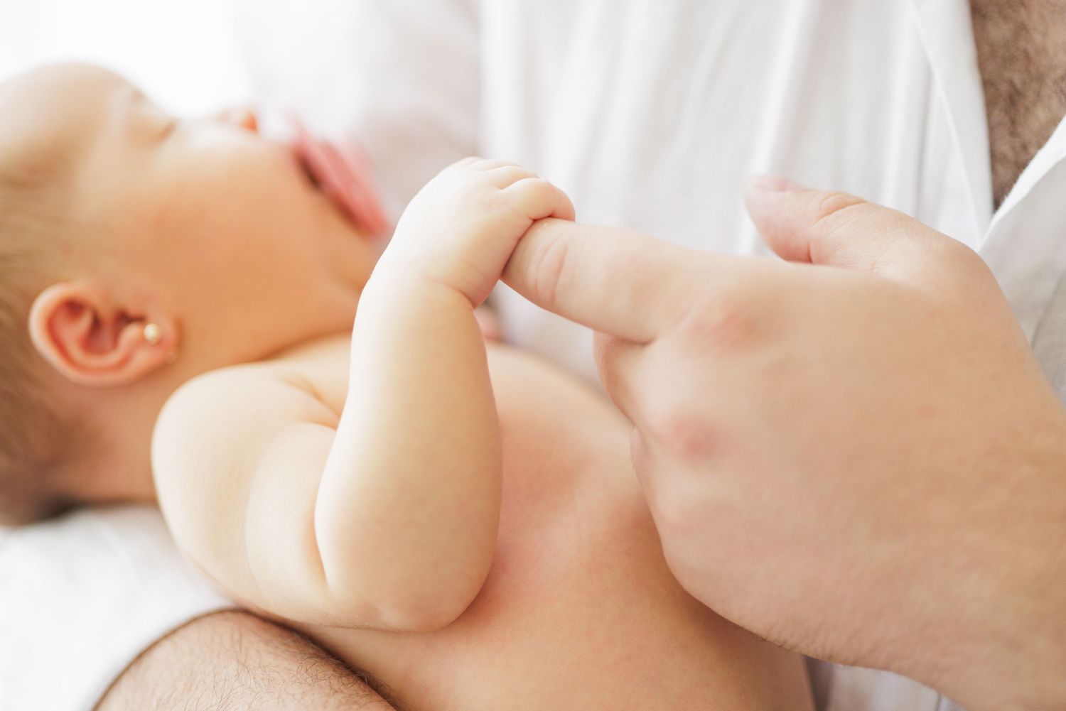 Close-up series of gentle moments with a newborn baby in soft lighting.