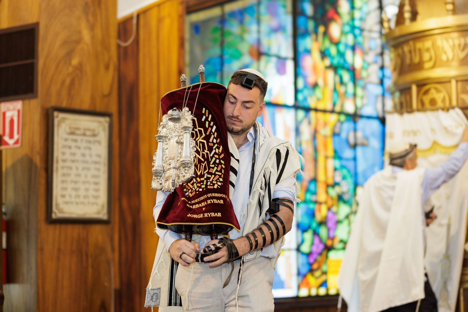 Religious service with stained glass windows and wooden interior.