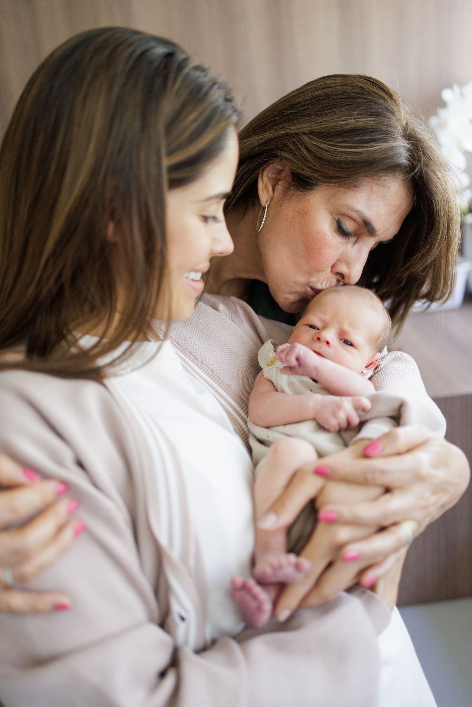 Tender moments between parent and newborn baby in soft natural lighting.