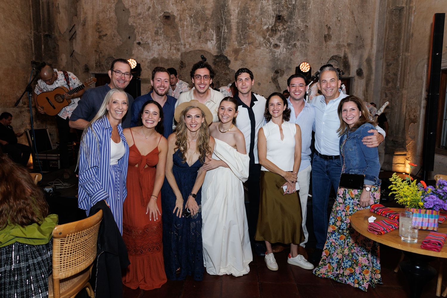 Large group photo of wedding guests and wedding party members at an evening celebration.