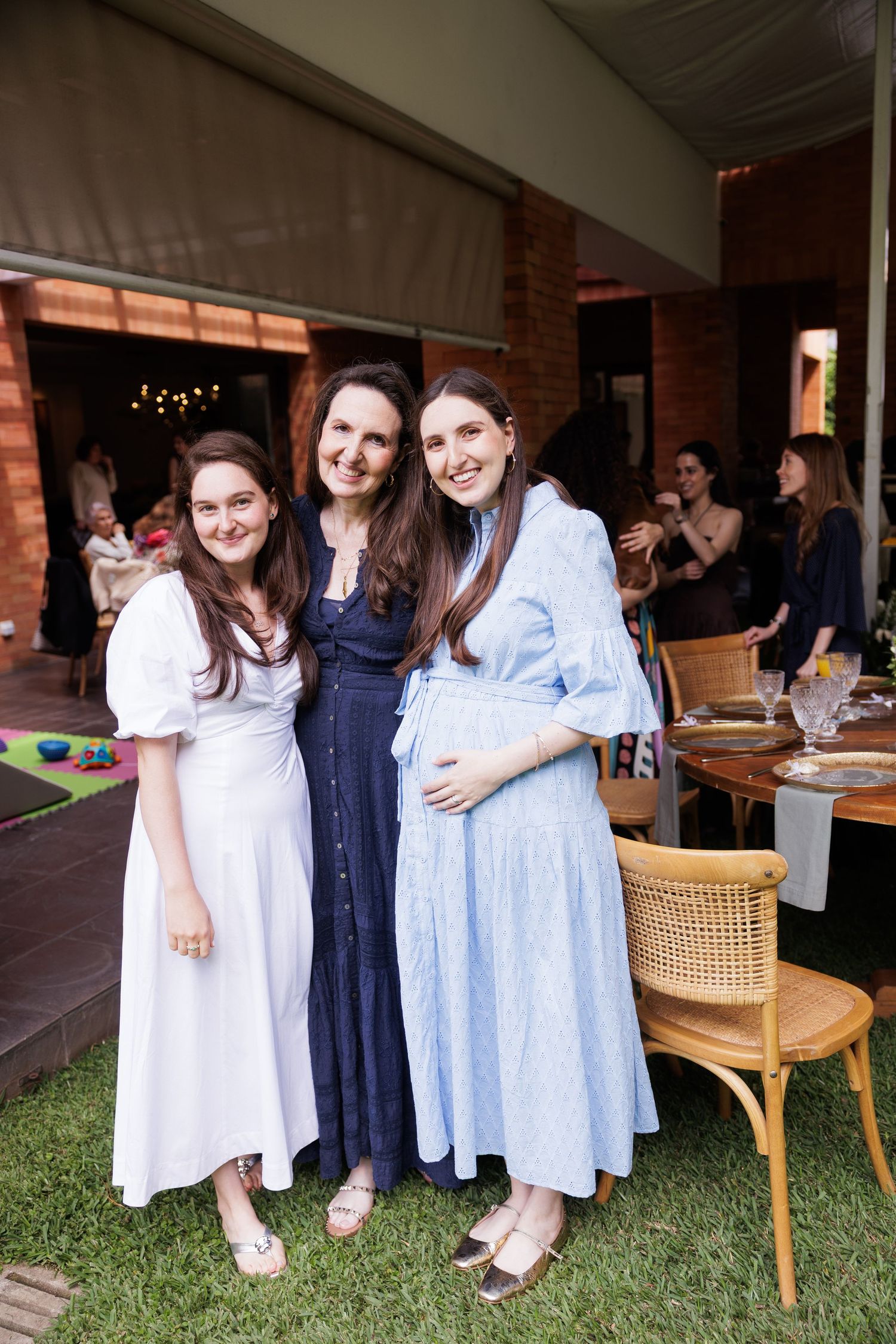 Friends gather at an outdoor venue wearing coordinated blue and white dresses.