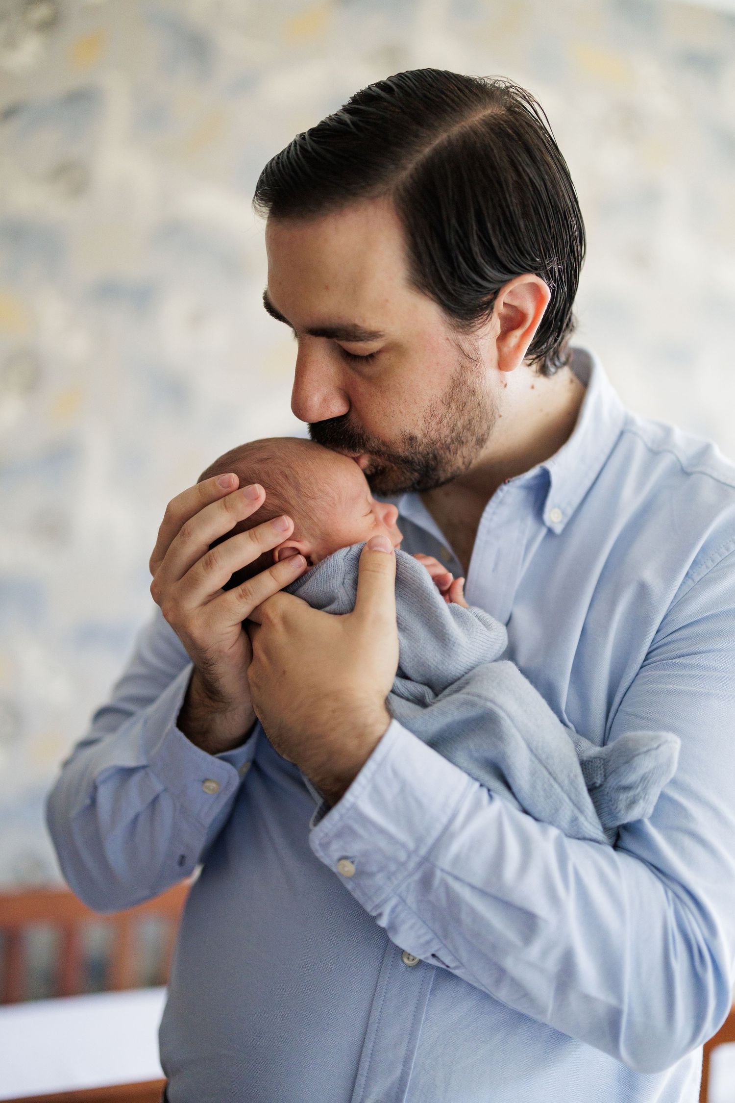 Emotional series of photos showing tender expressions in front of patterned wallpaper.