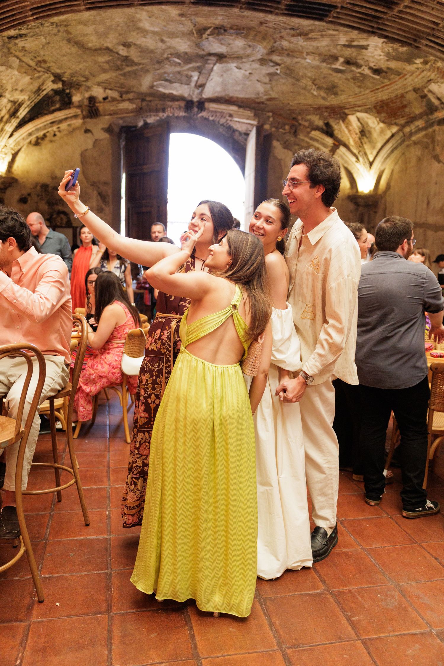 Guests dancing and celebrating in a rustic stone venue with terracotta floors.