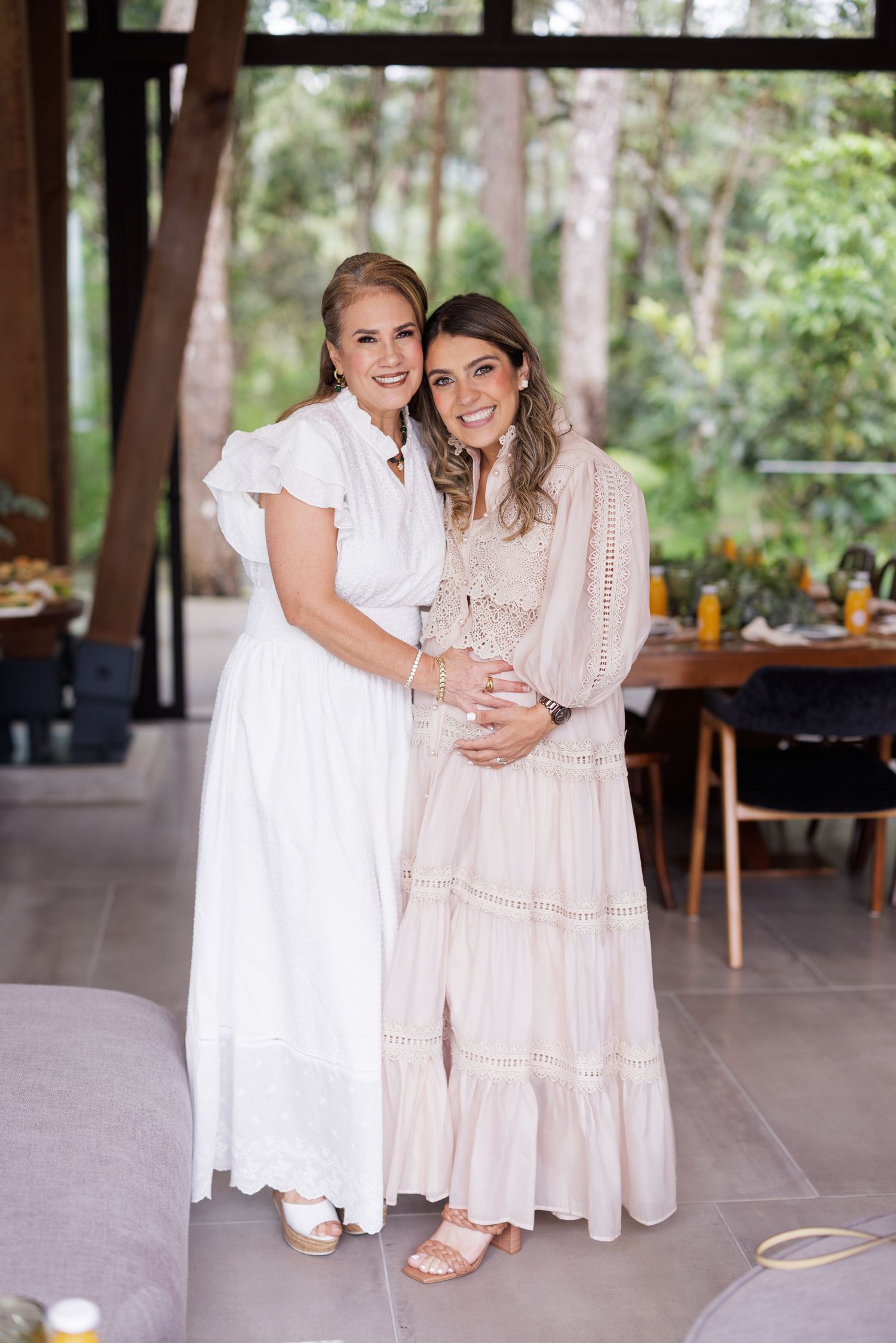 Two people share embraces while sitting in a covered outdoor venue with wooden beams.