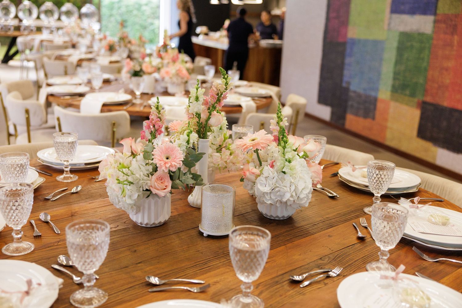 Elegant wedding reception table setting with floral centerpieces and crystal glassware.