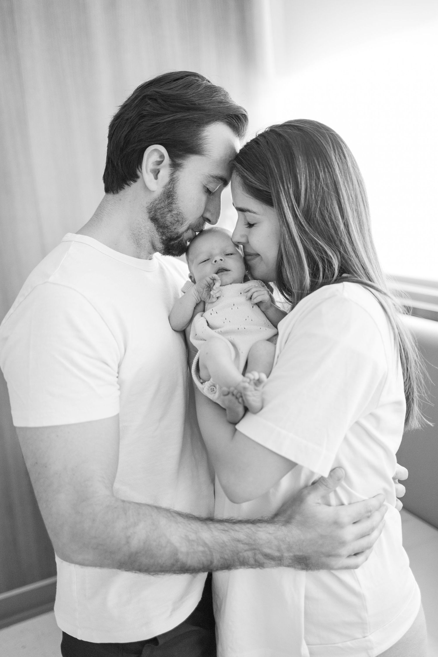 Intimate family moment captured in soft black and white photography.
