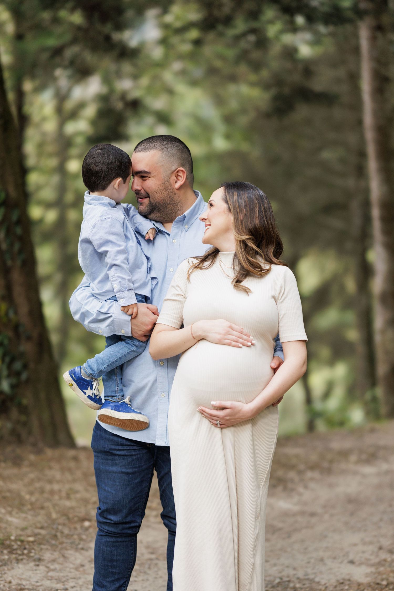 Family sharing tender moments together in a wooded setting.