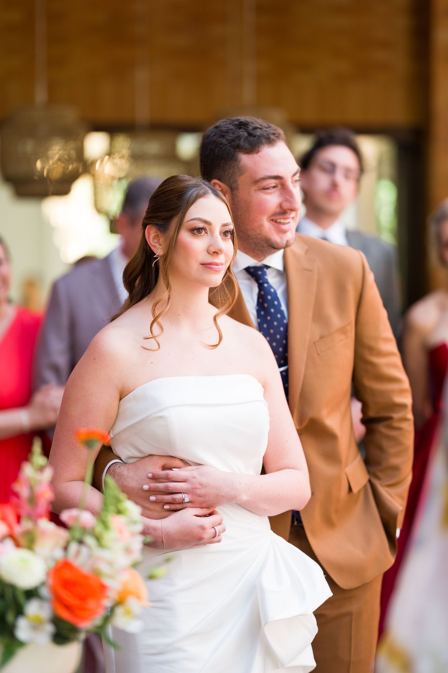 A couple shares a tender moment during their wedding reception in a rustic venue.