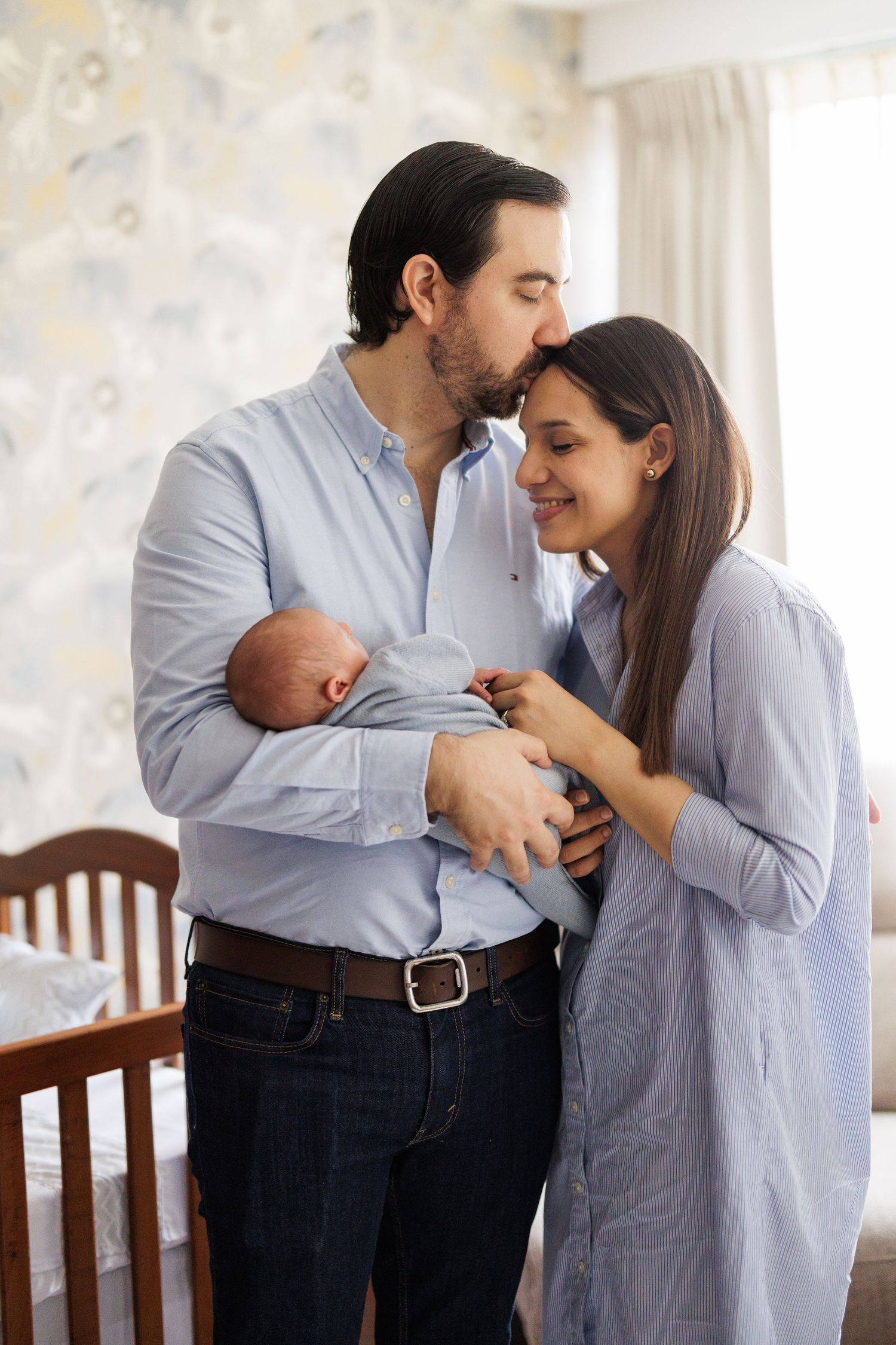 Sweet family interactions captured in a nursery setting with natural lighting.