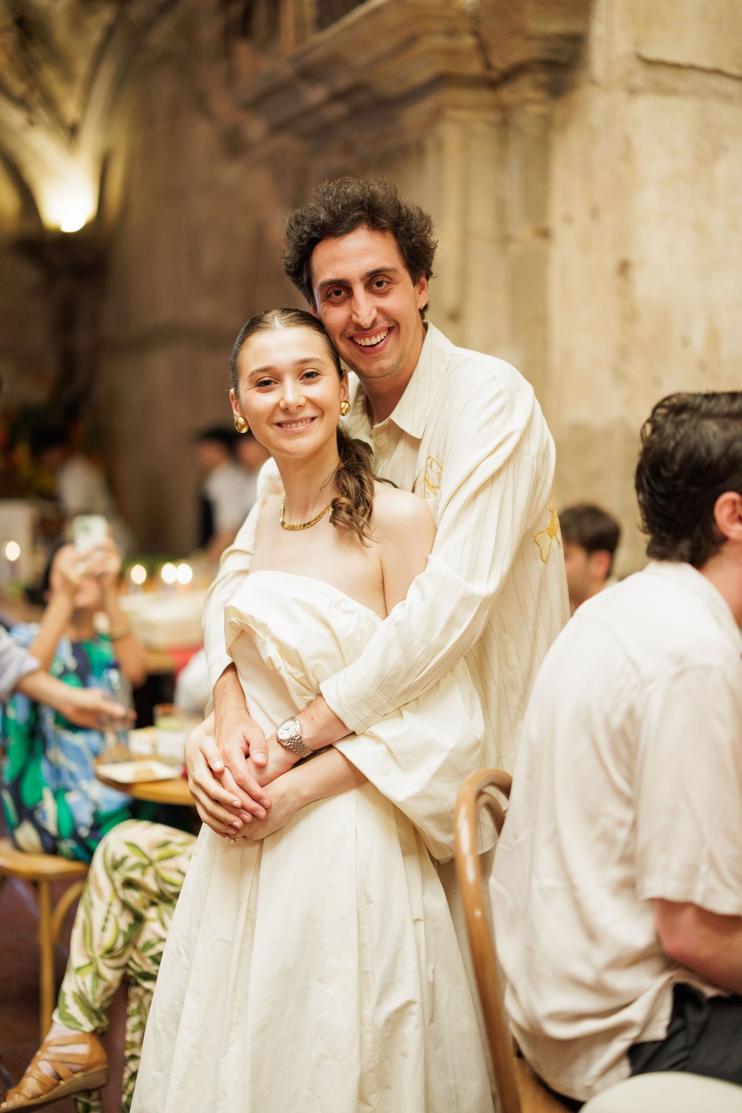 Celebration candid moments at elegant indoor reception with stone walls and archways.
