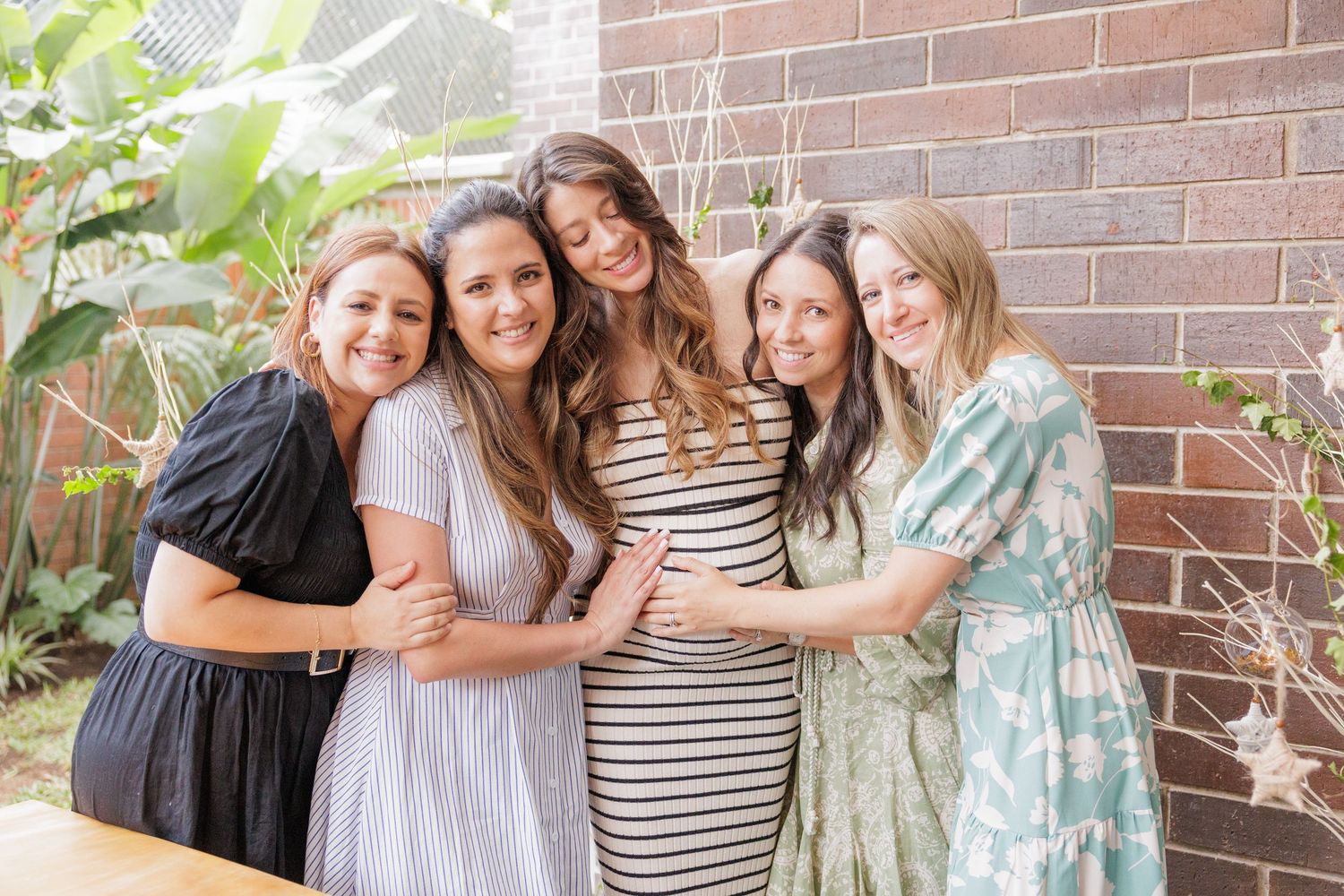 Group photo of wedding party members embracing and smiling together.