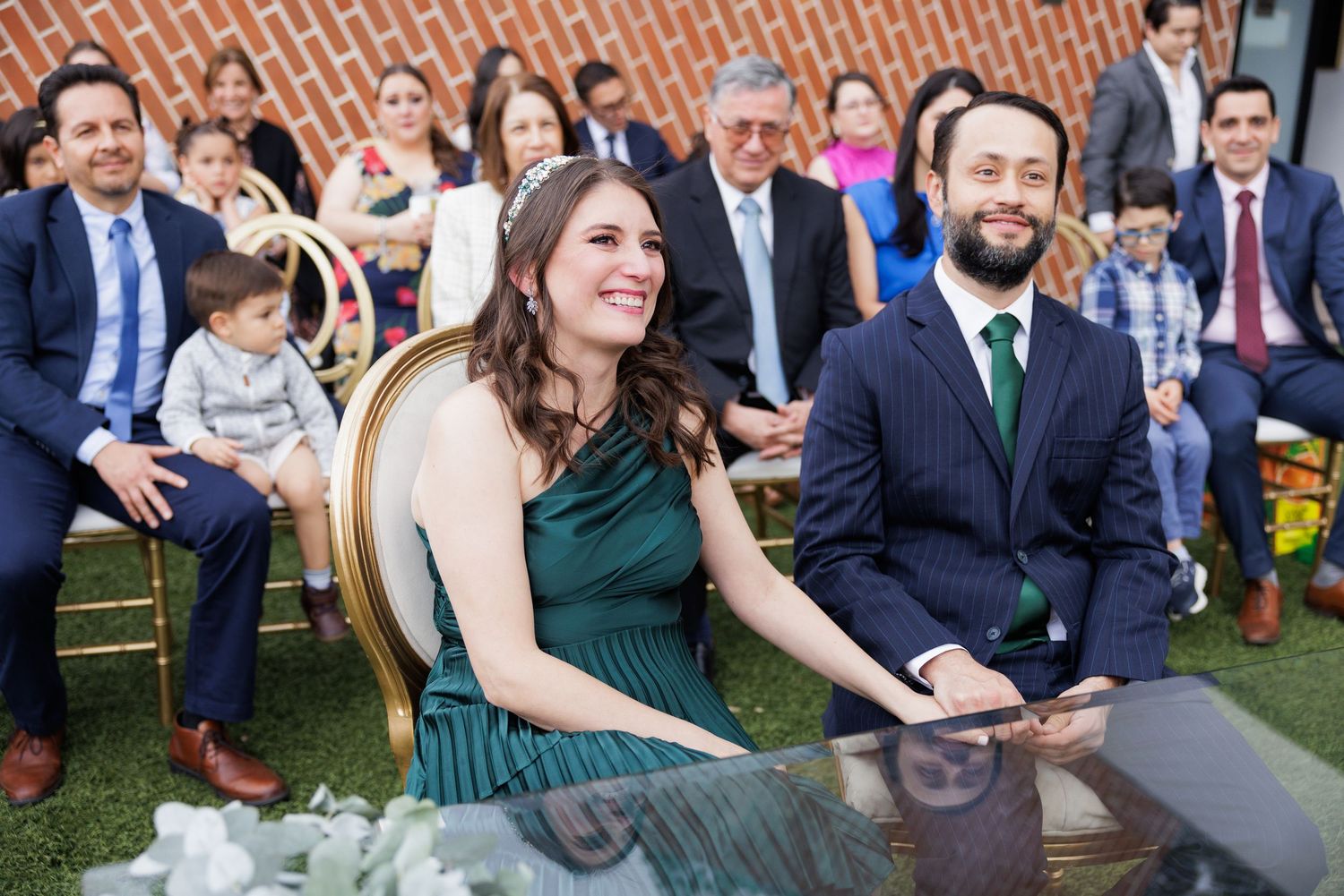 Wedding guests gathered outdoors watching a ceremony with smiles and laughter.
