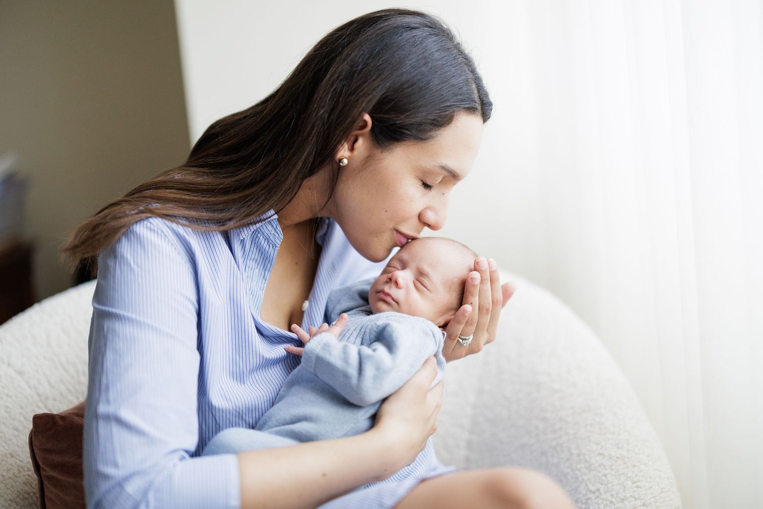 Gentle moments captured in soft lighting against white curtains.