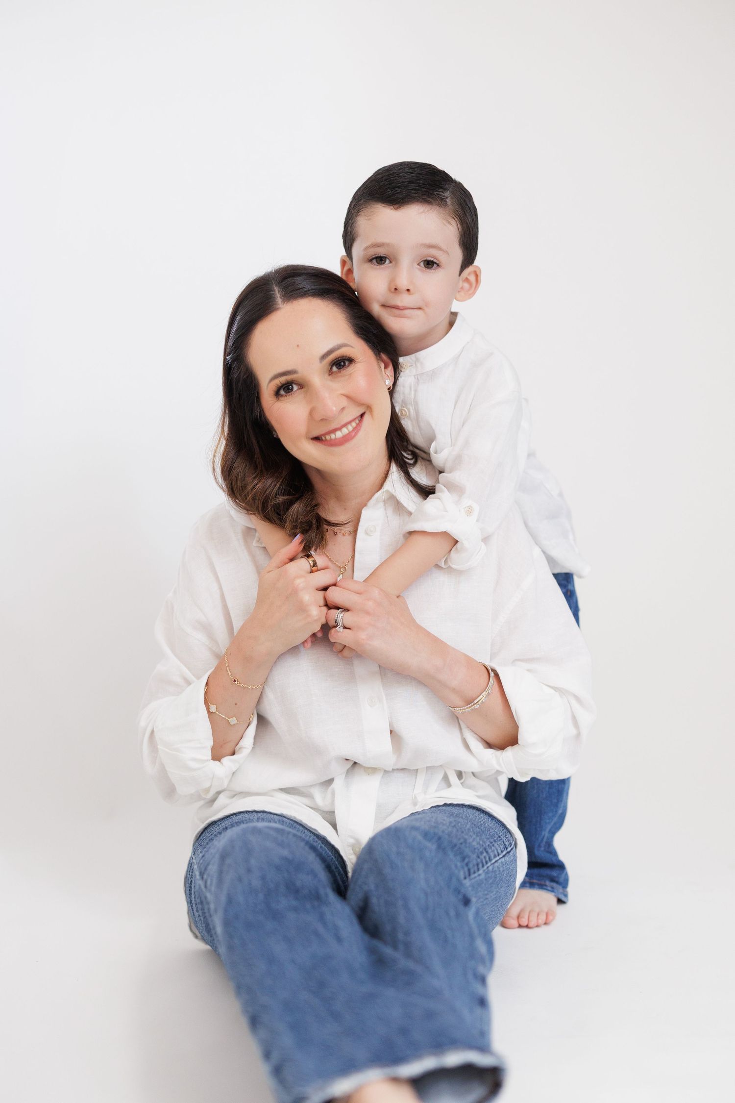 Mother and child sharing affectionate moments against white background.