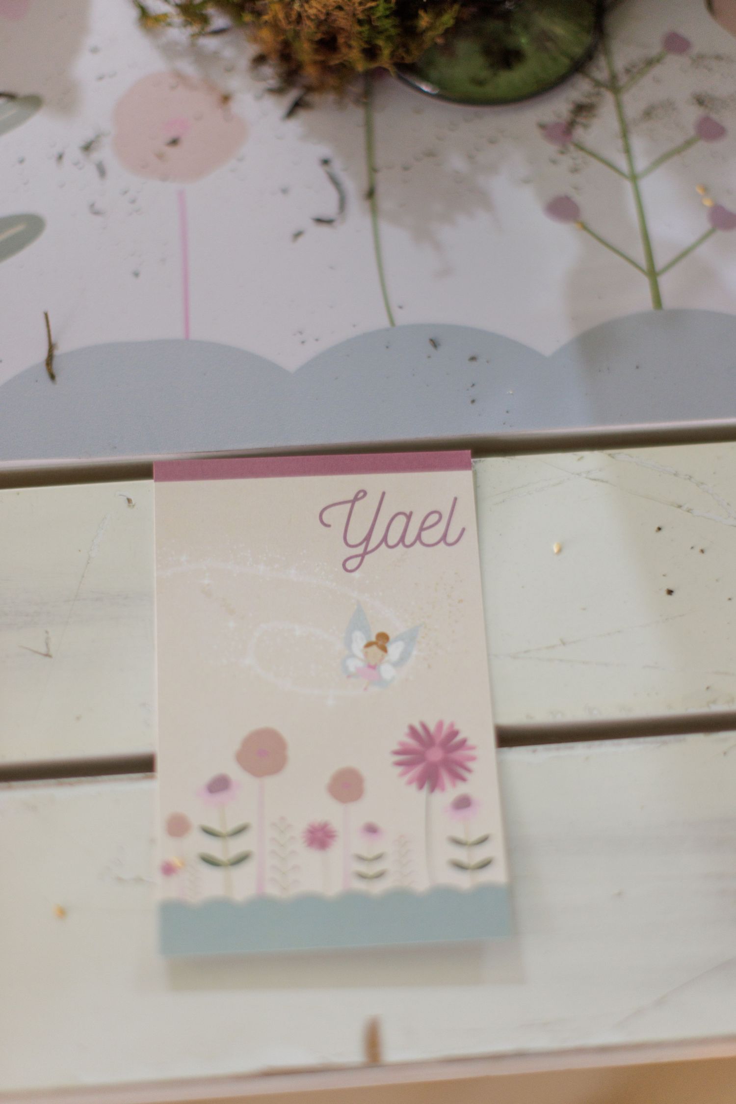 Delicate floral place cards with pink and blue watercolor designs on a white surface.