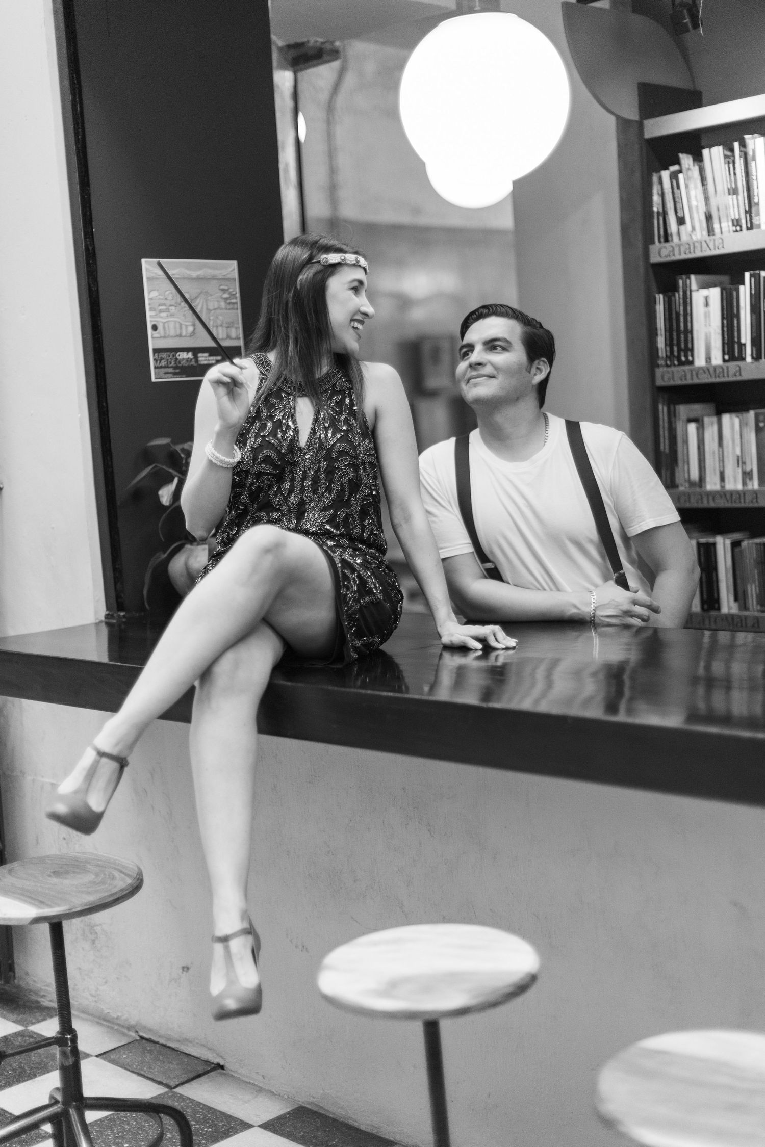 Black and white sequence showing couple sitting and interacting in library setting.