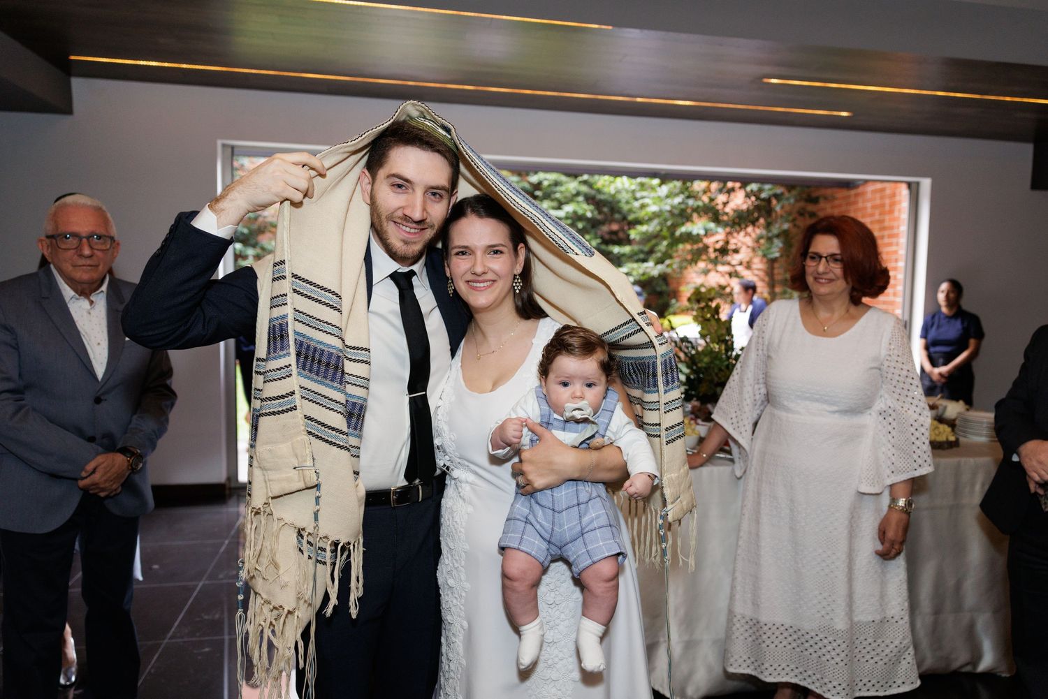 A joyous celebration moment with guests wearing traditional religious garments in an indoor venue.