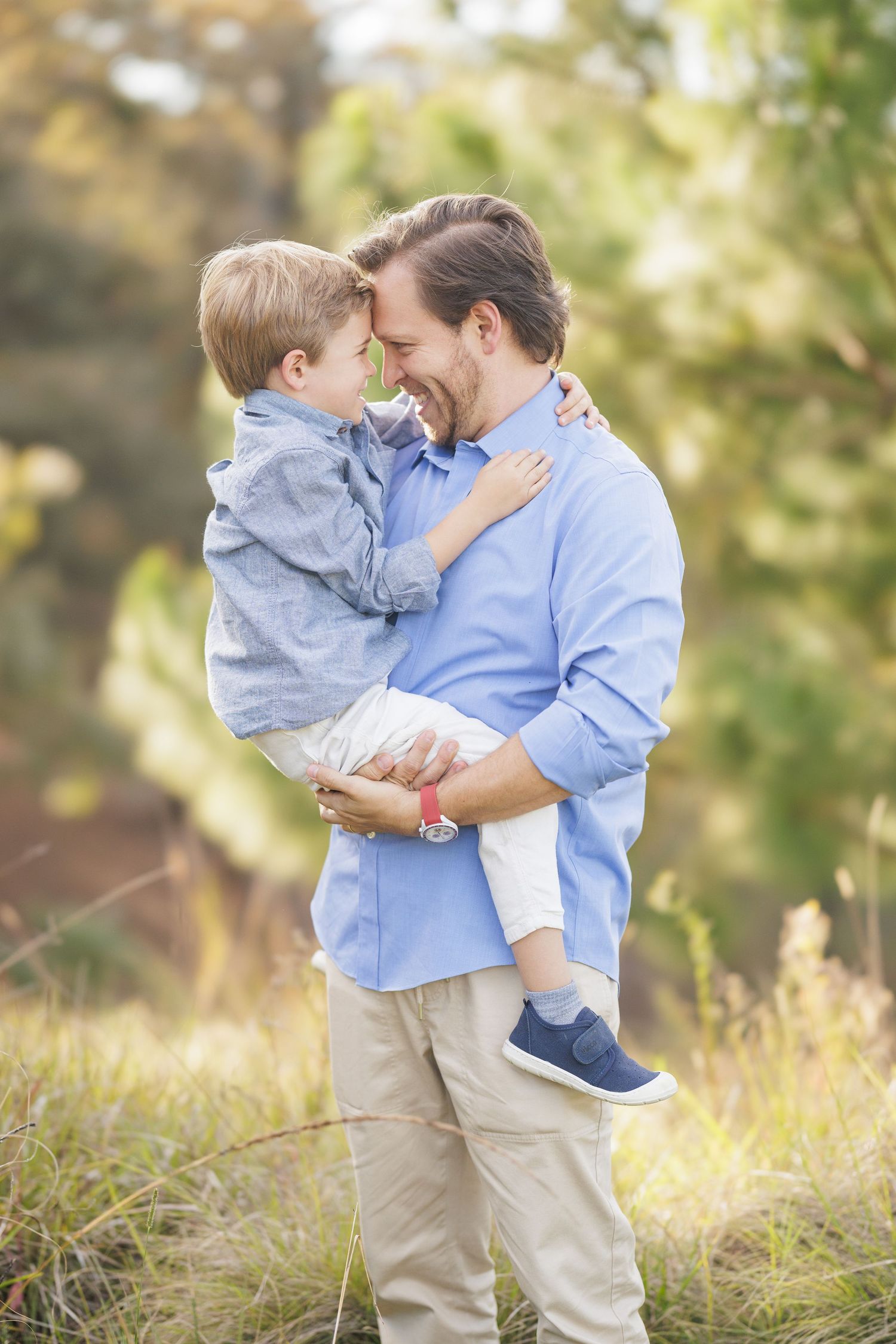 Parent and child sharing a tender moment in a sunlit field.