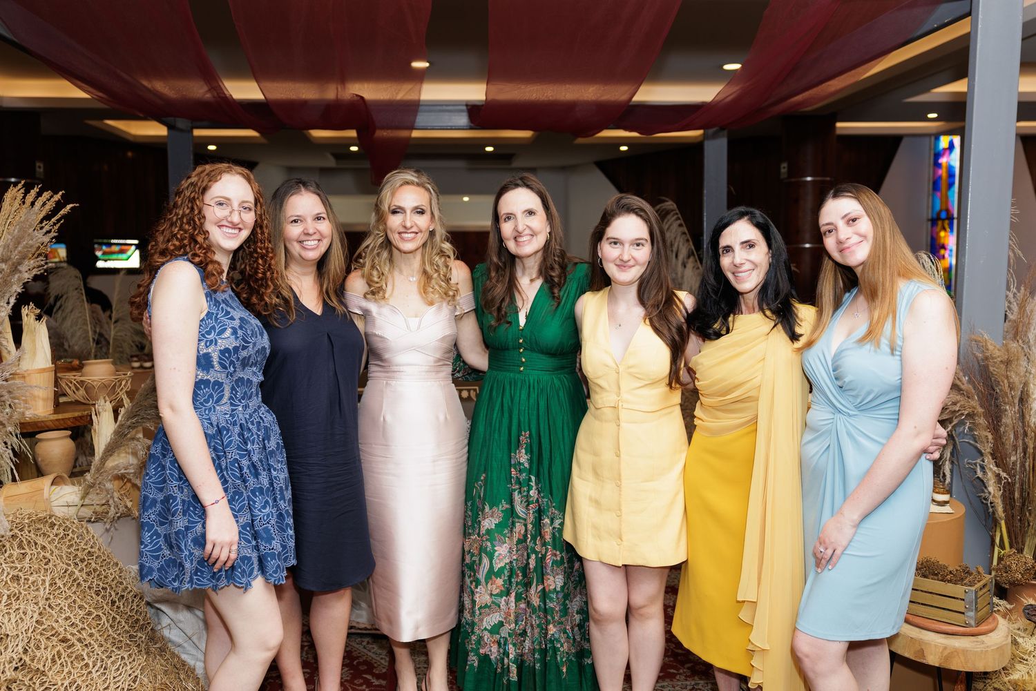 Group photo showing people wearing coordinated outfits in shades of green, yellow and blue.