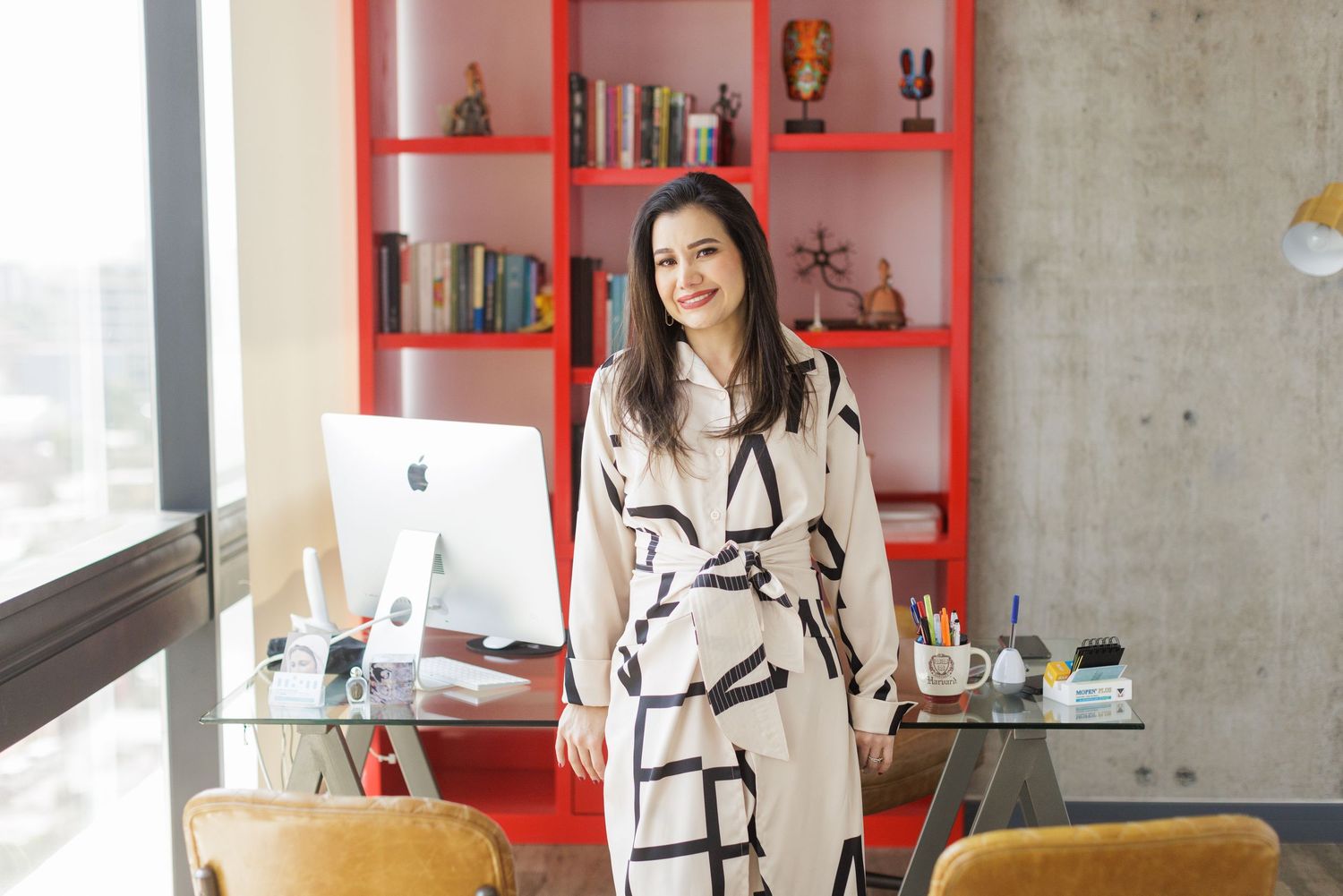 Modern office space with bright red shelving units and industrial concrete walls.