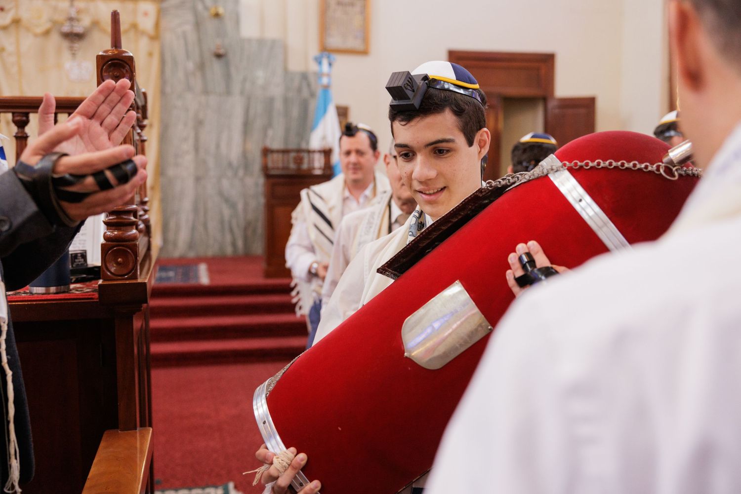 Participants in white prayer shawls gathered near the altar during a religious ceremony.
