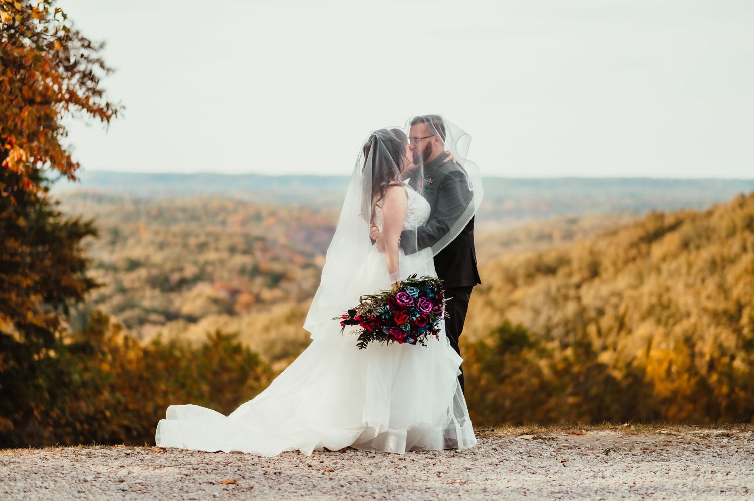 Bride and groom kissing at Hesitation Point in Brown County State Park during a fall Indiana wedding