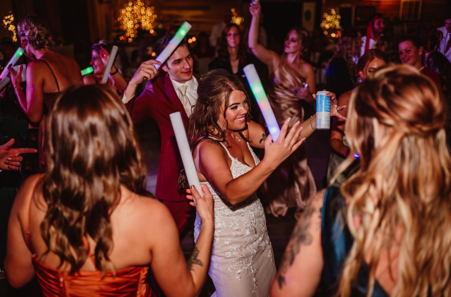 Bride dancing joyfully with guests holding glowing foam sticks at The Barn at Timber Ridge in Brown County, Indiana.