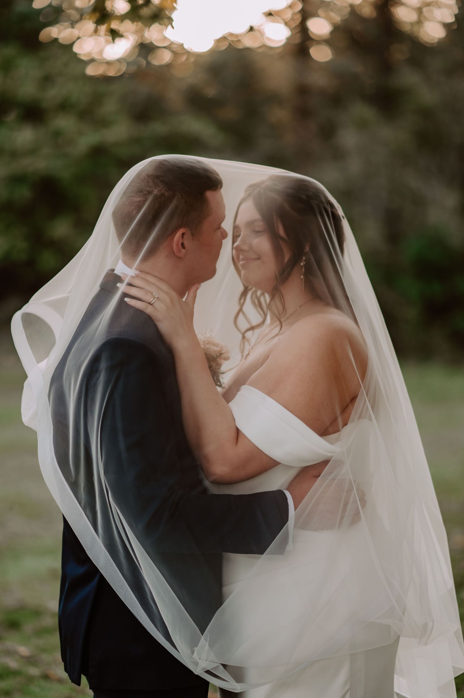 Bride and groom share romantic moment under the veil during golden hour at Laurel Mill venue in Brown County Indiana
