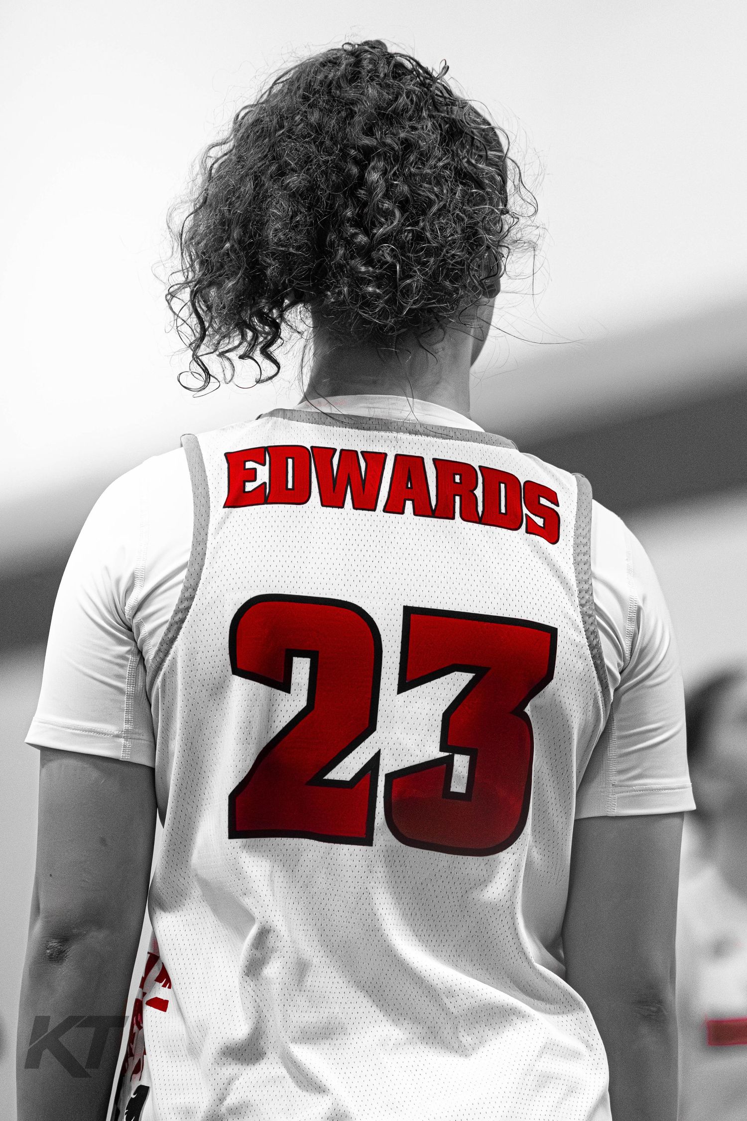 Basketball player Edwards wearing jersey number 23, viewed from behind in selective color photography.