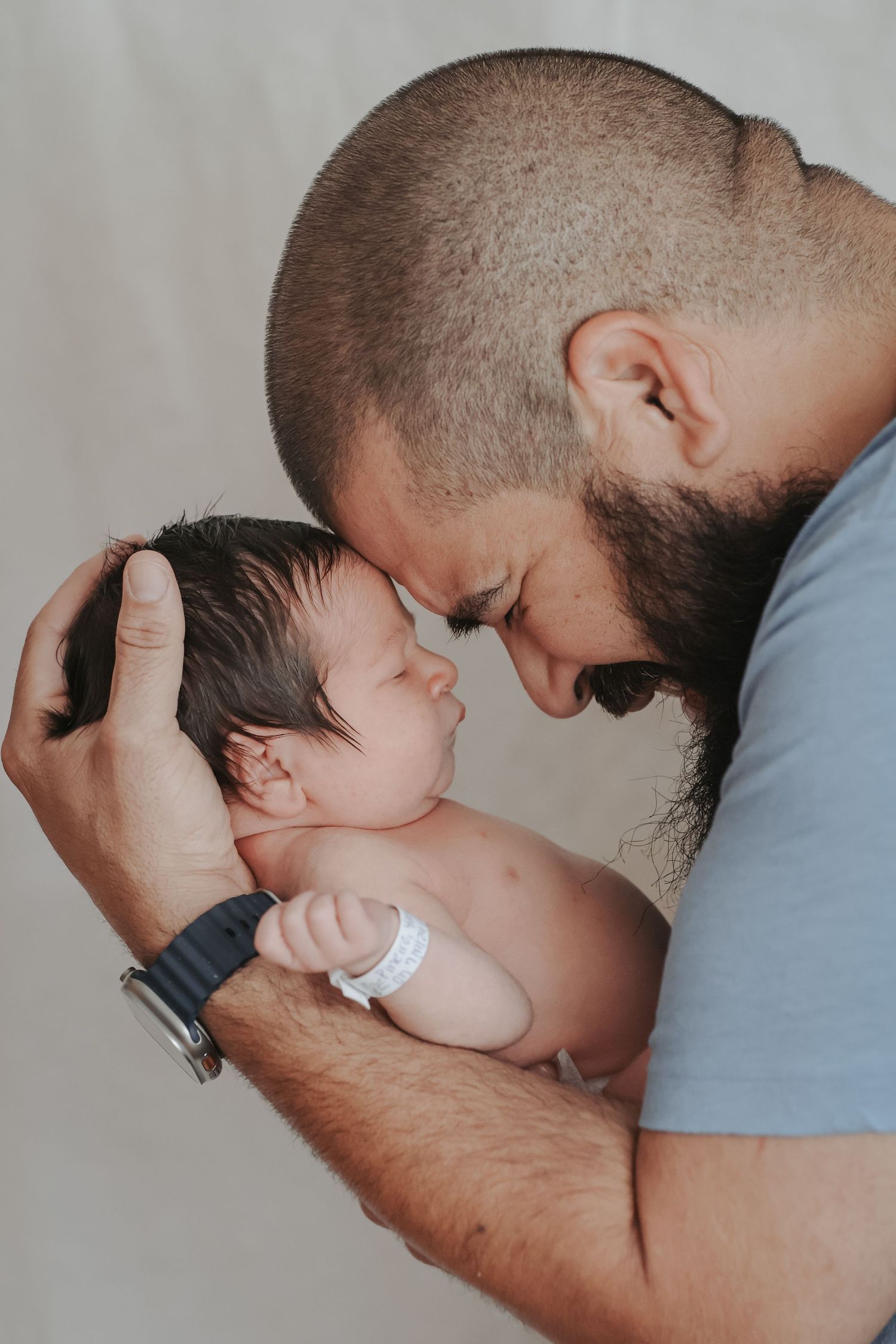 Father kissing his newborn baby during an intimate lifestyle newborn session In Oak Ridge, TN