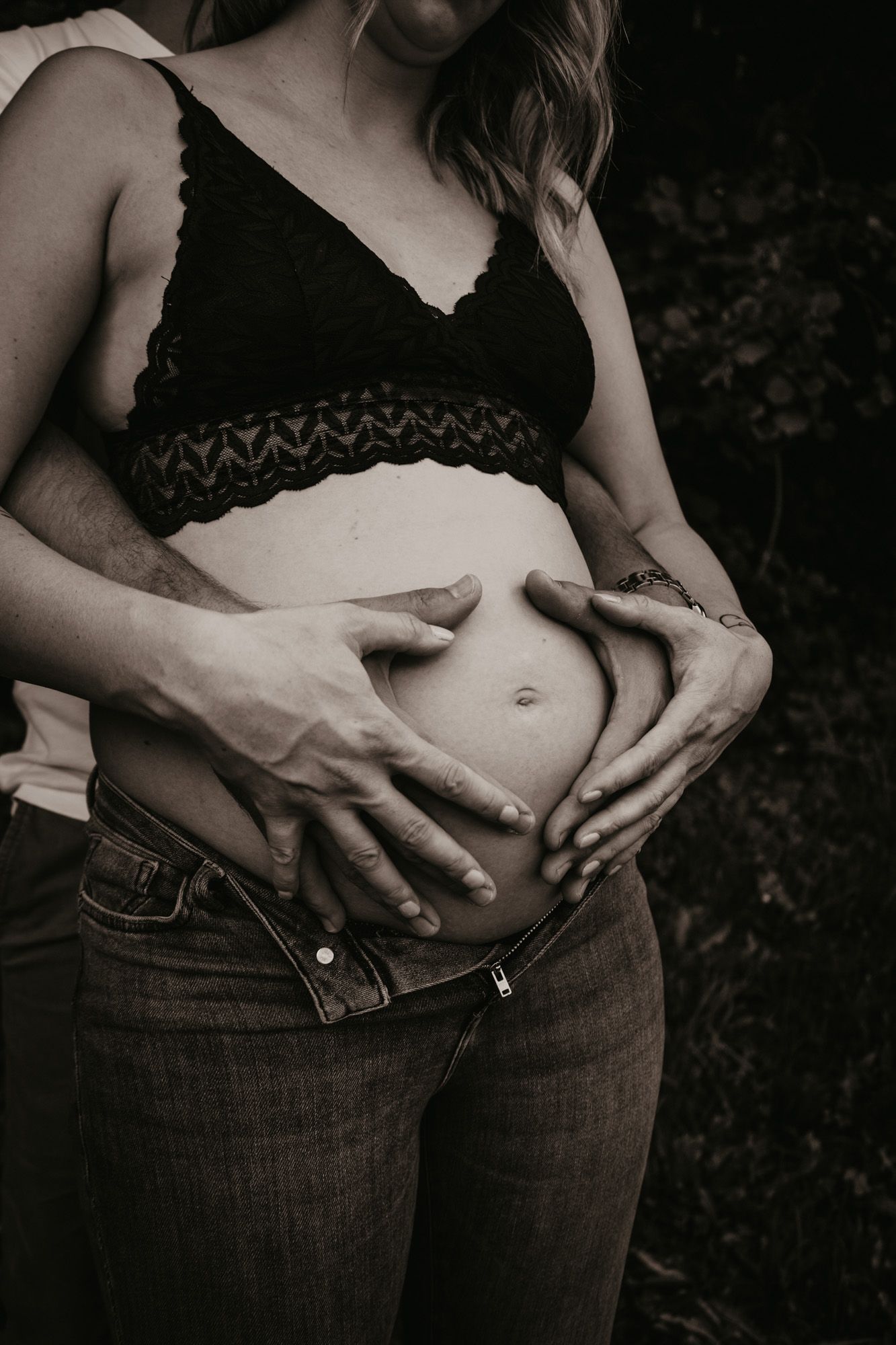 Black and white artistic series showing pregnancy belly with hands framing the bump.