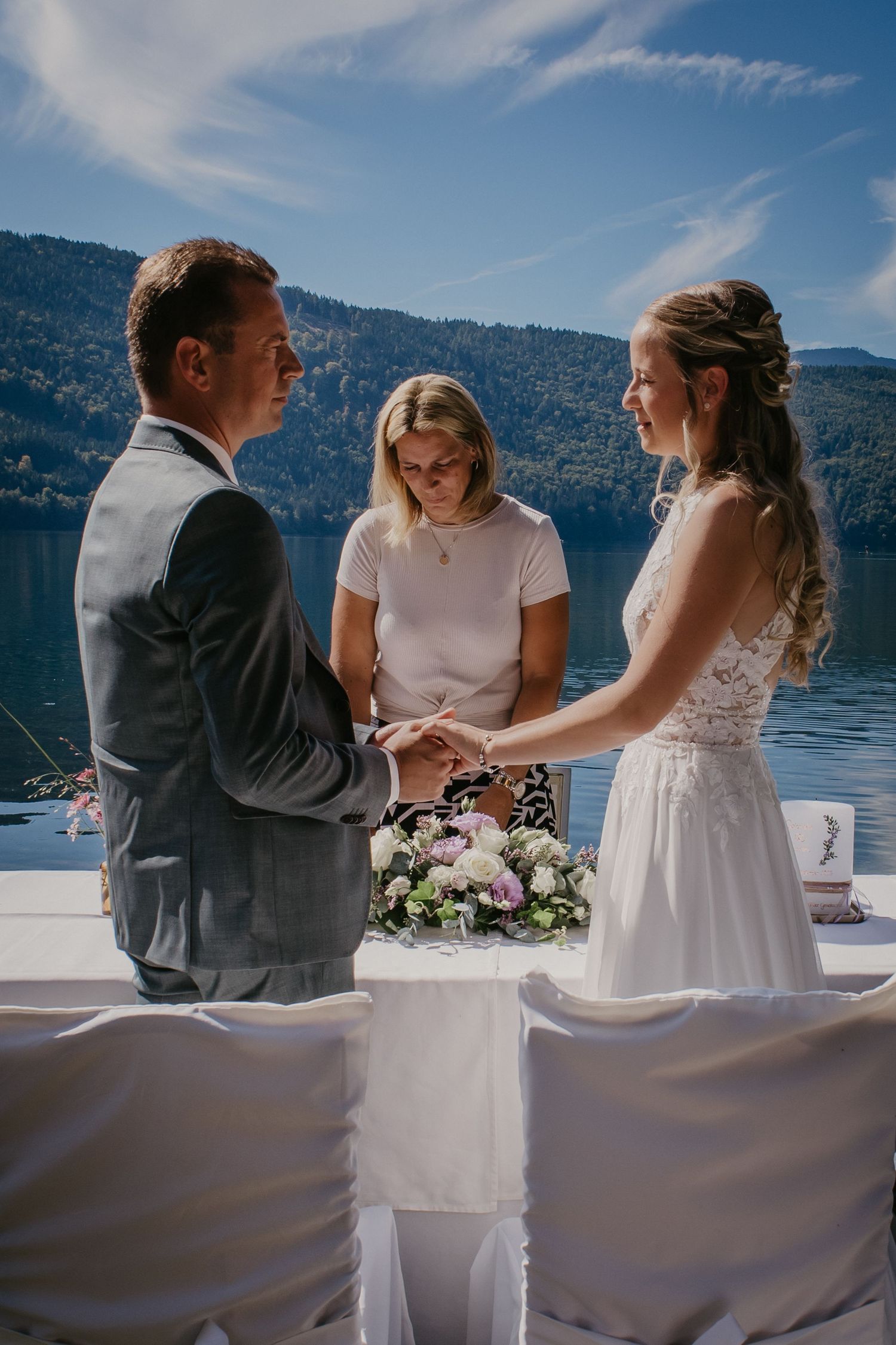 Outdoor lakeside wedding ceremony with mountain scenery in the background.