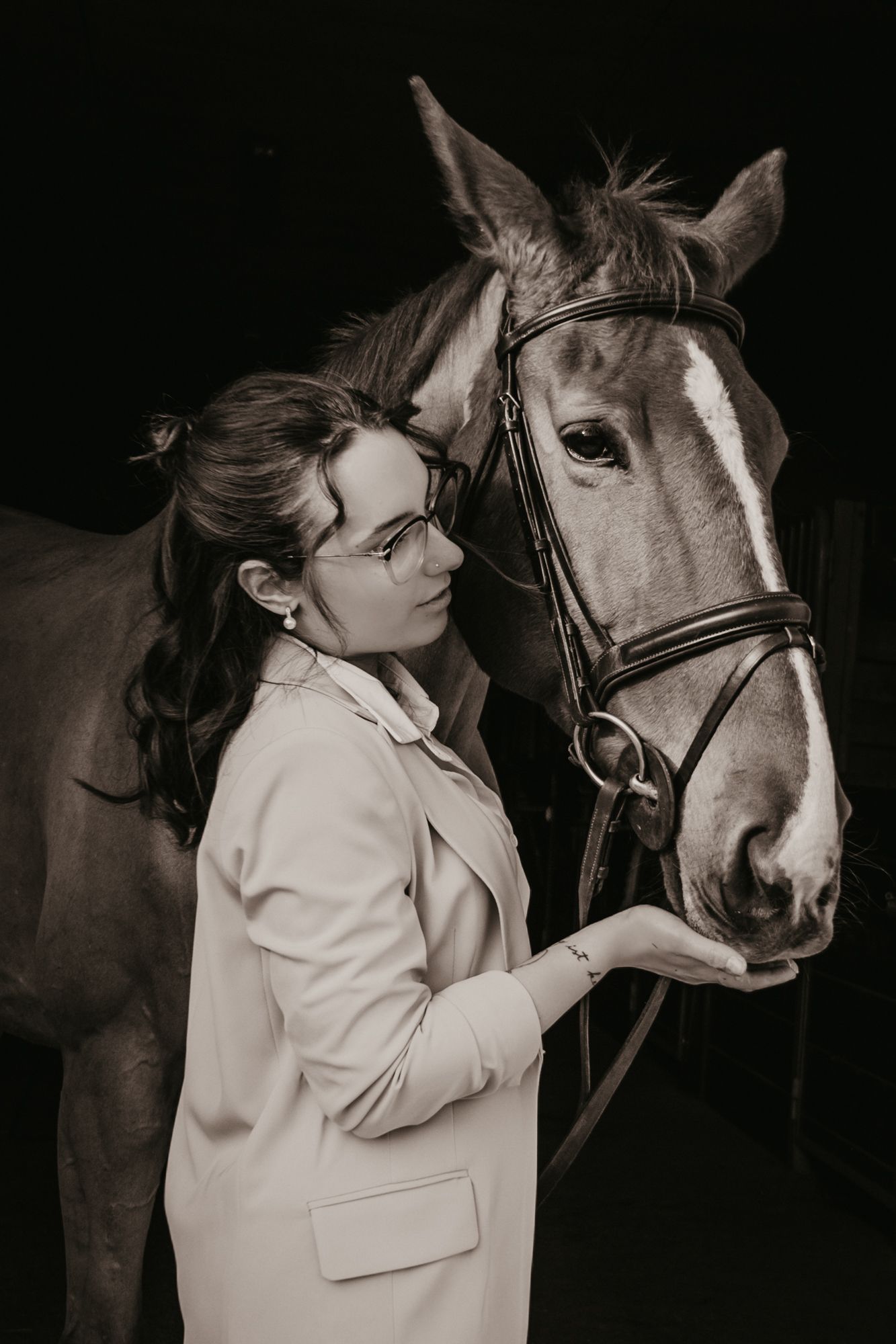 Black and white portrait series showing an intimate moment between a horse and someone in a white coat.
