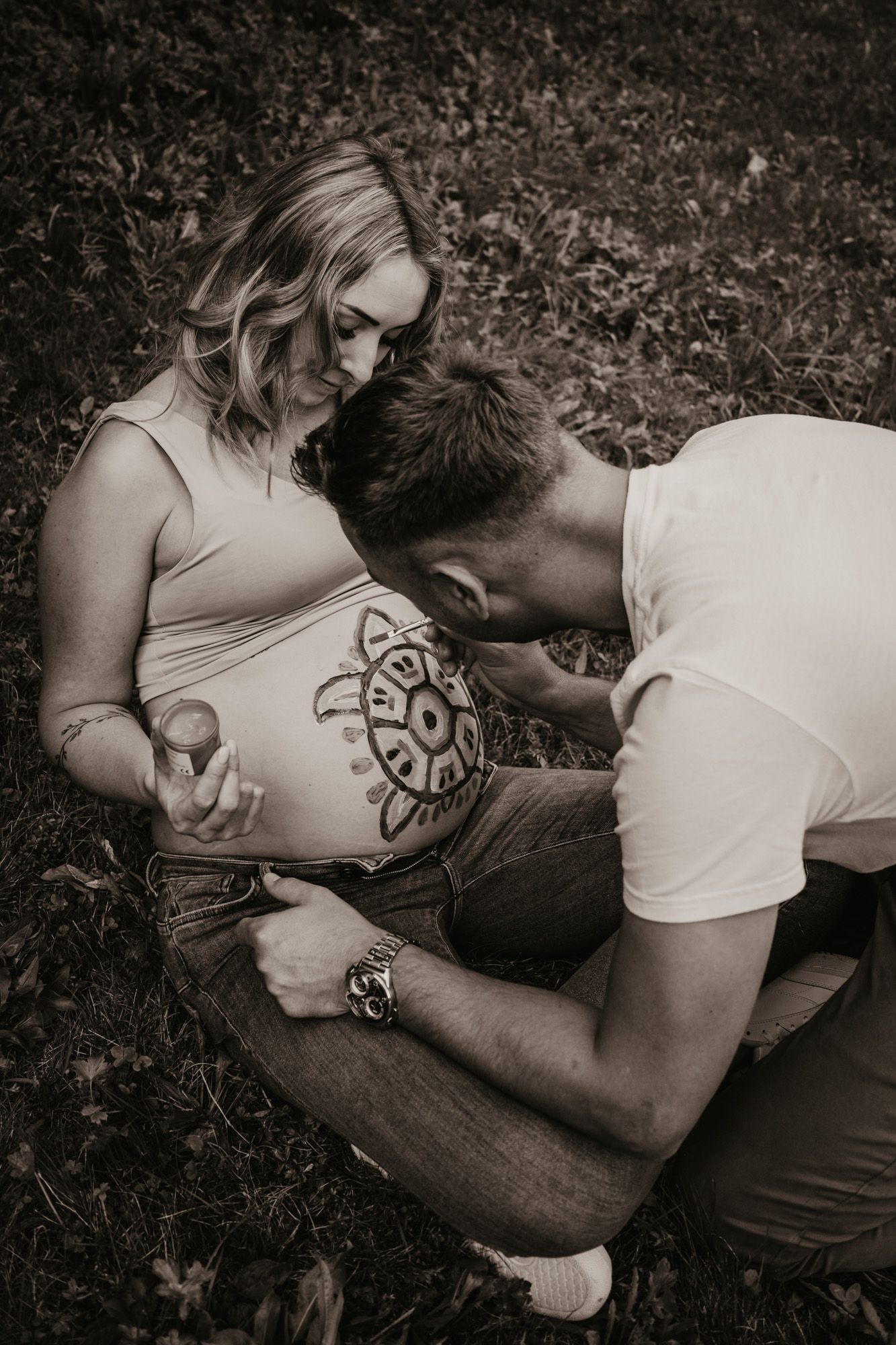 Black and white series capturing intimate moments during belly art session.