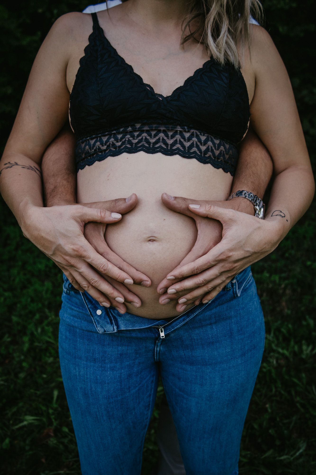 Series of intimate belly shots showing pregnancy progression in blue jeans.