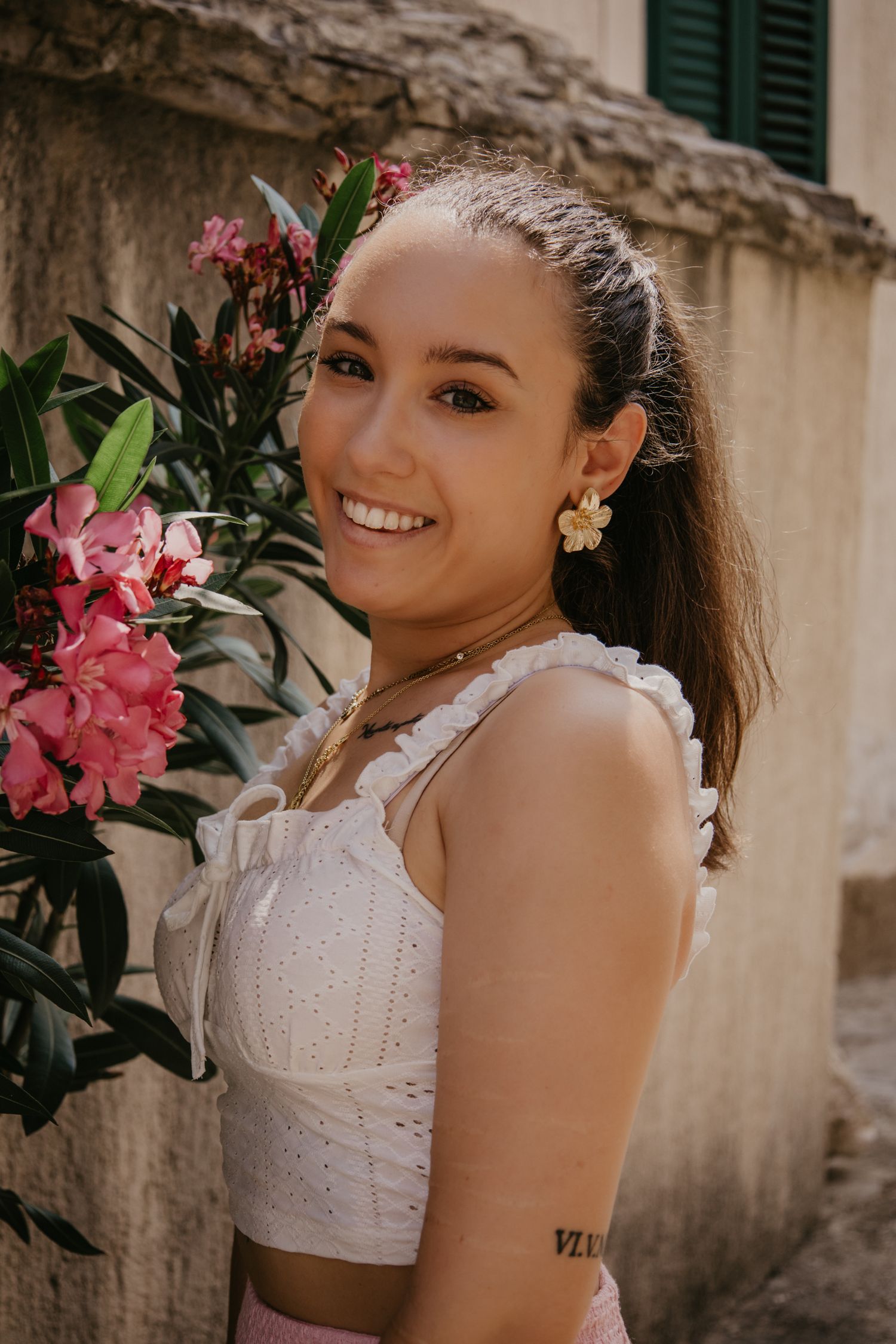 Summer fashion portraits with pink flowers and white eyelet top.