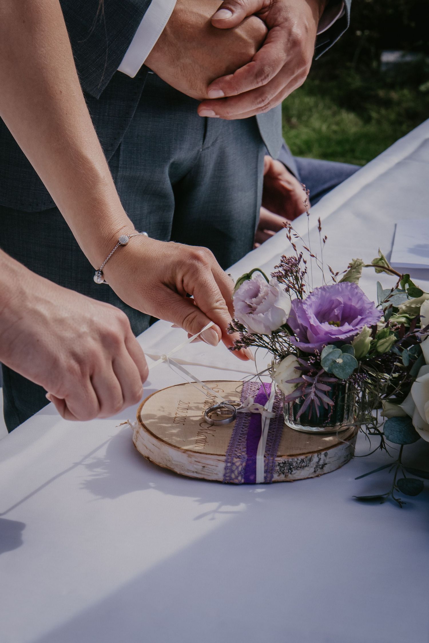 Close-up of hands arranging decorative elements on a white tablecloth.