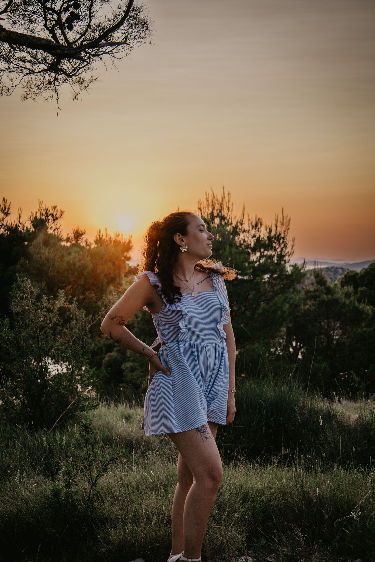 A dreamy sunset photoshoot in a natural outdoor setting with a light blue ruffled top.